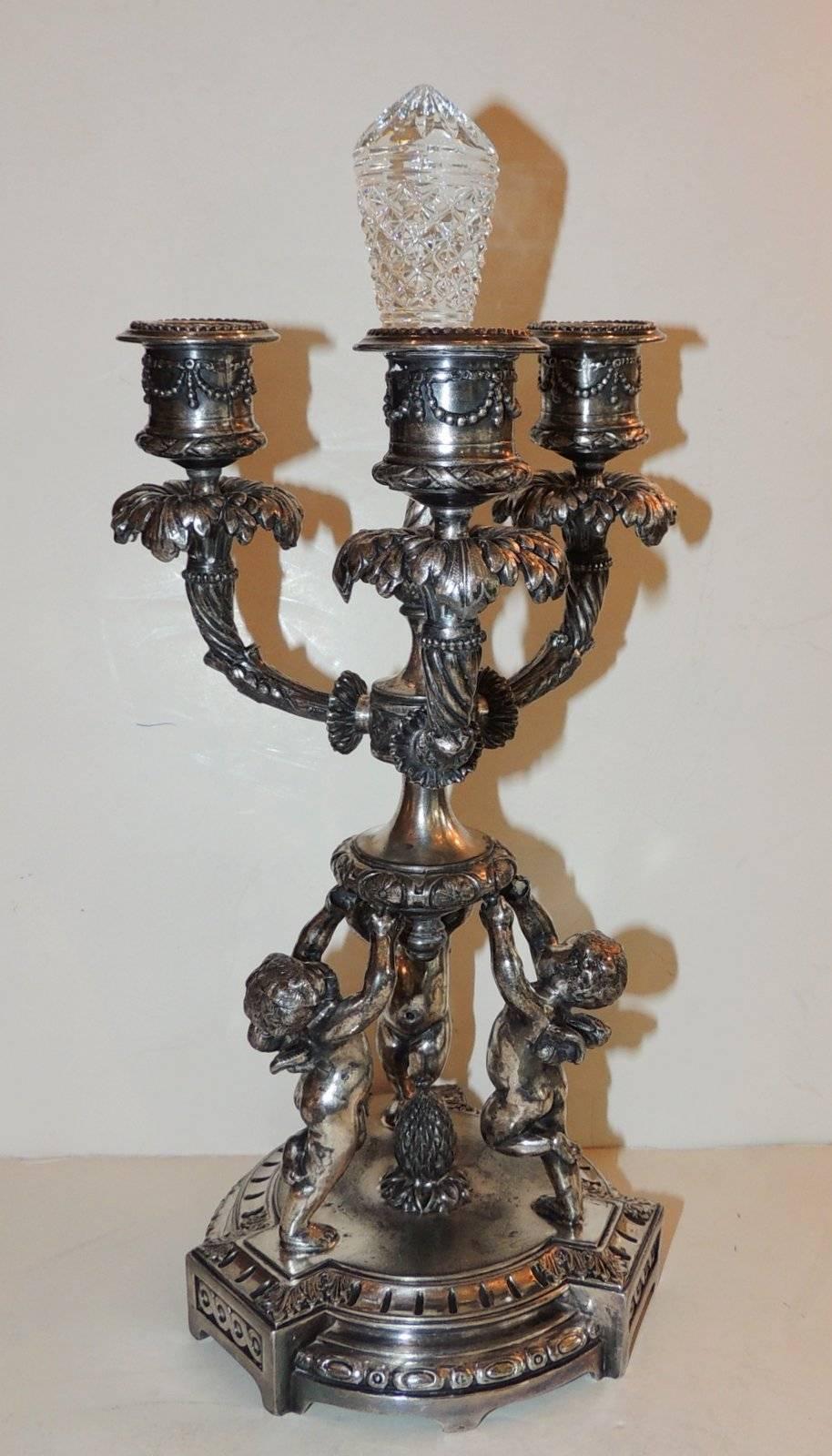 Wonderful pair of pairpoint silvered bronze trio cherub candelabras with wonderful engraved details, three arms and delicate cut crystal centre.

Measures: 12.5