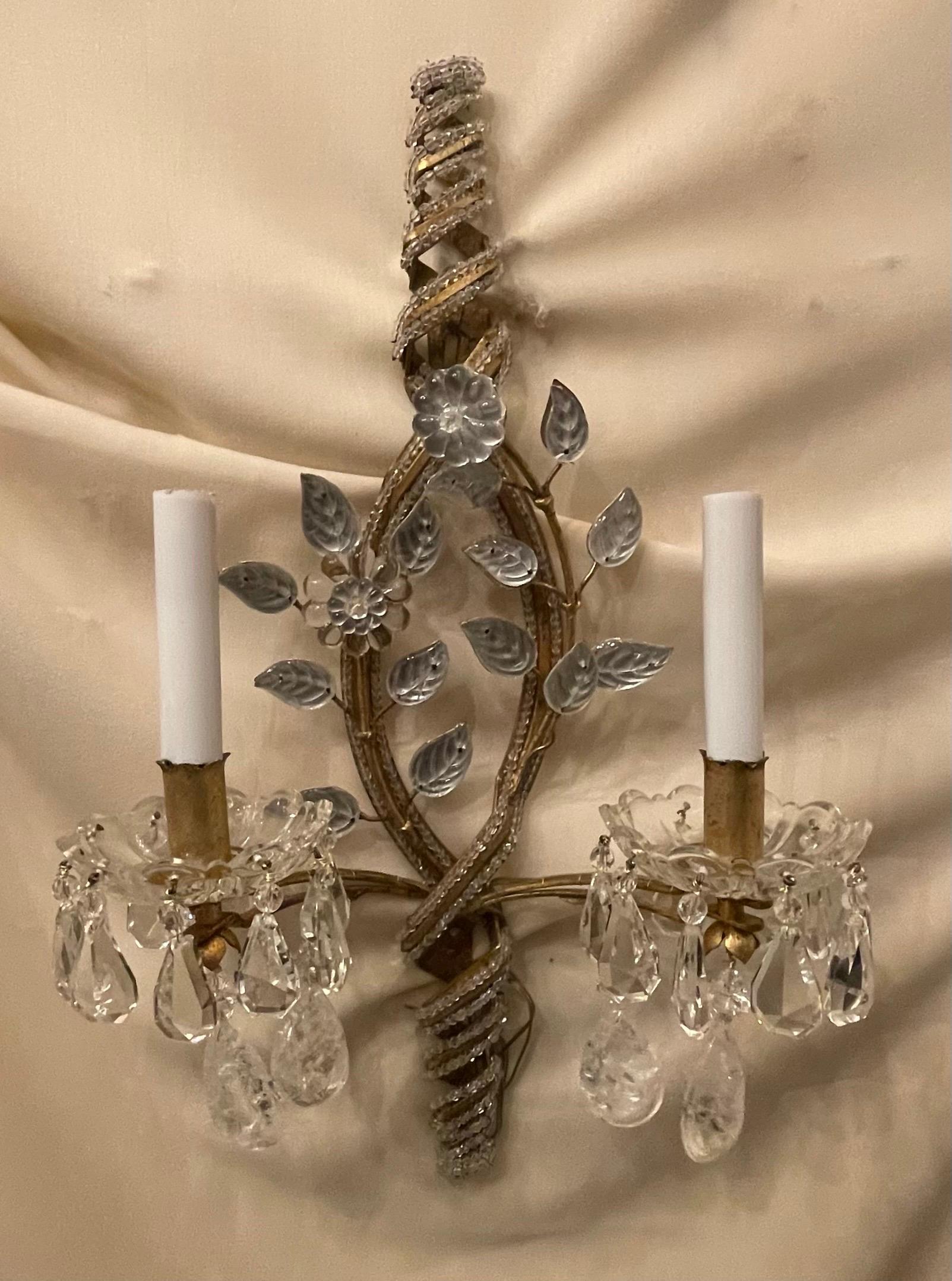 A wonderful pair of gold gilt, rock crystal drop Maison Bagues style sconces with beaded spiral design leading to two candelabra lights situated inside clear cups. The sconces have been rewired with new sockets and come ready to install.