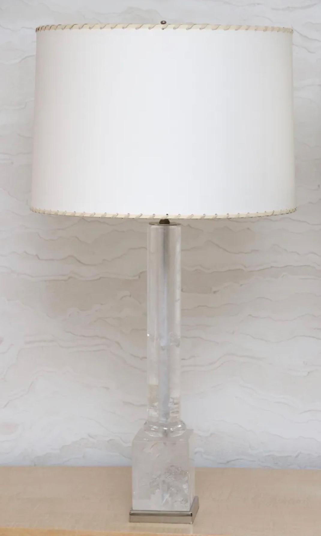 A wonderful pair of rock crystal columnar form lamps in the manner of Maison Baguès with square form rock crystal base supported by a square form polished nickel base. Each lamp includes a round faux suede lamp shade with stitching accent trim on