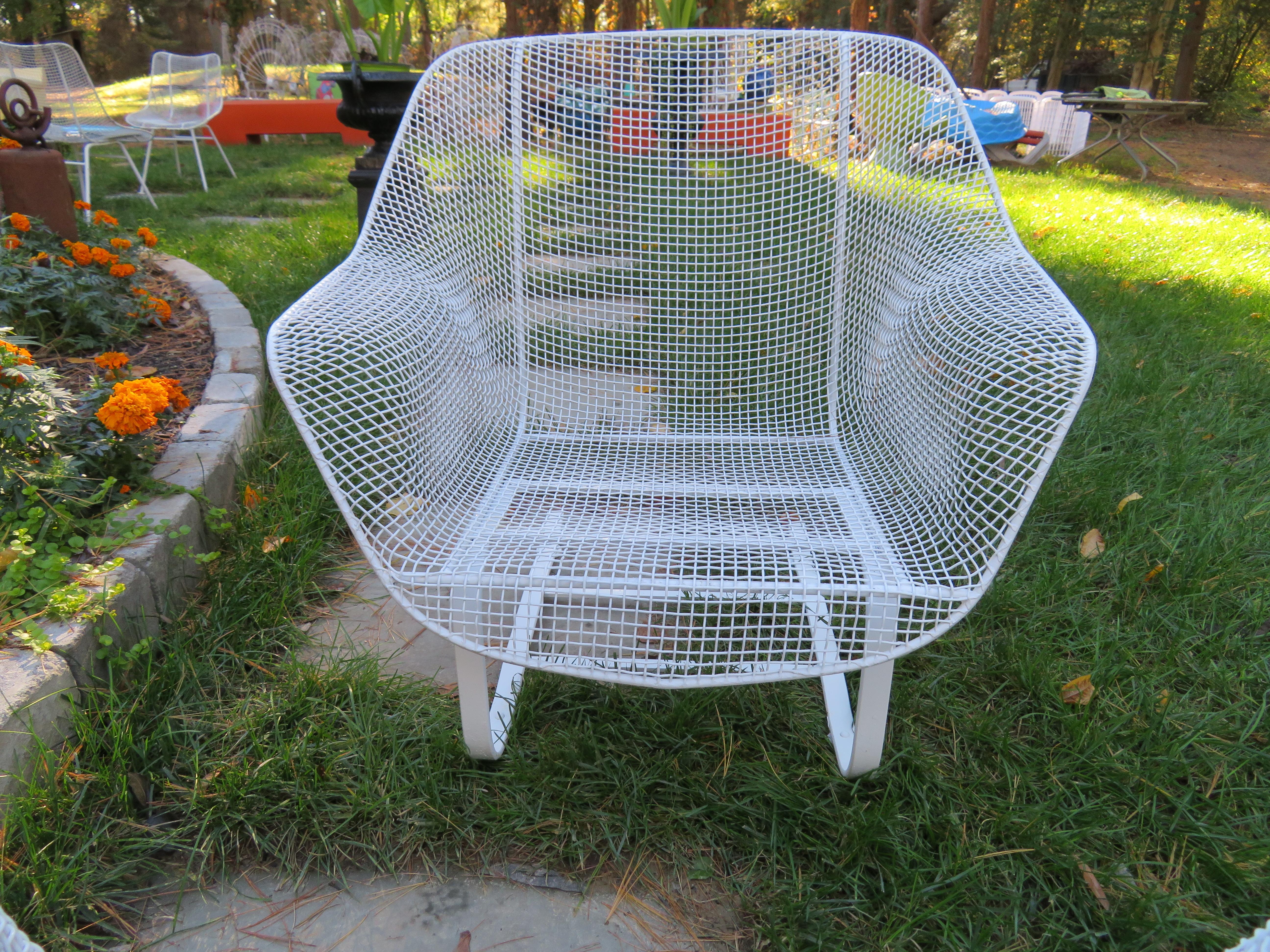 Wonderful pair of 1950s 'Sculptura' lounge chairs designed by John Woodard. Woodard's Sculptura collection was made with wrought iron frames and woven steel mesh seats. These are the largest lounge chairs made by Woodard and have the more desirable