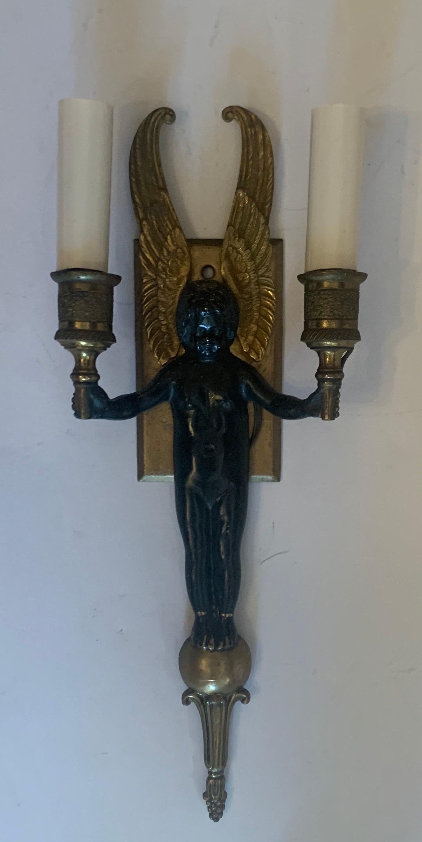 A wonderful French pair, or set of three patinated two-tone bronze gilt winged cherub empire two light sconces.
 
  