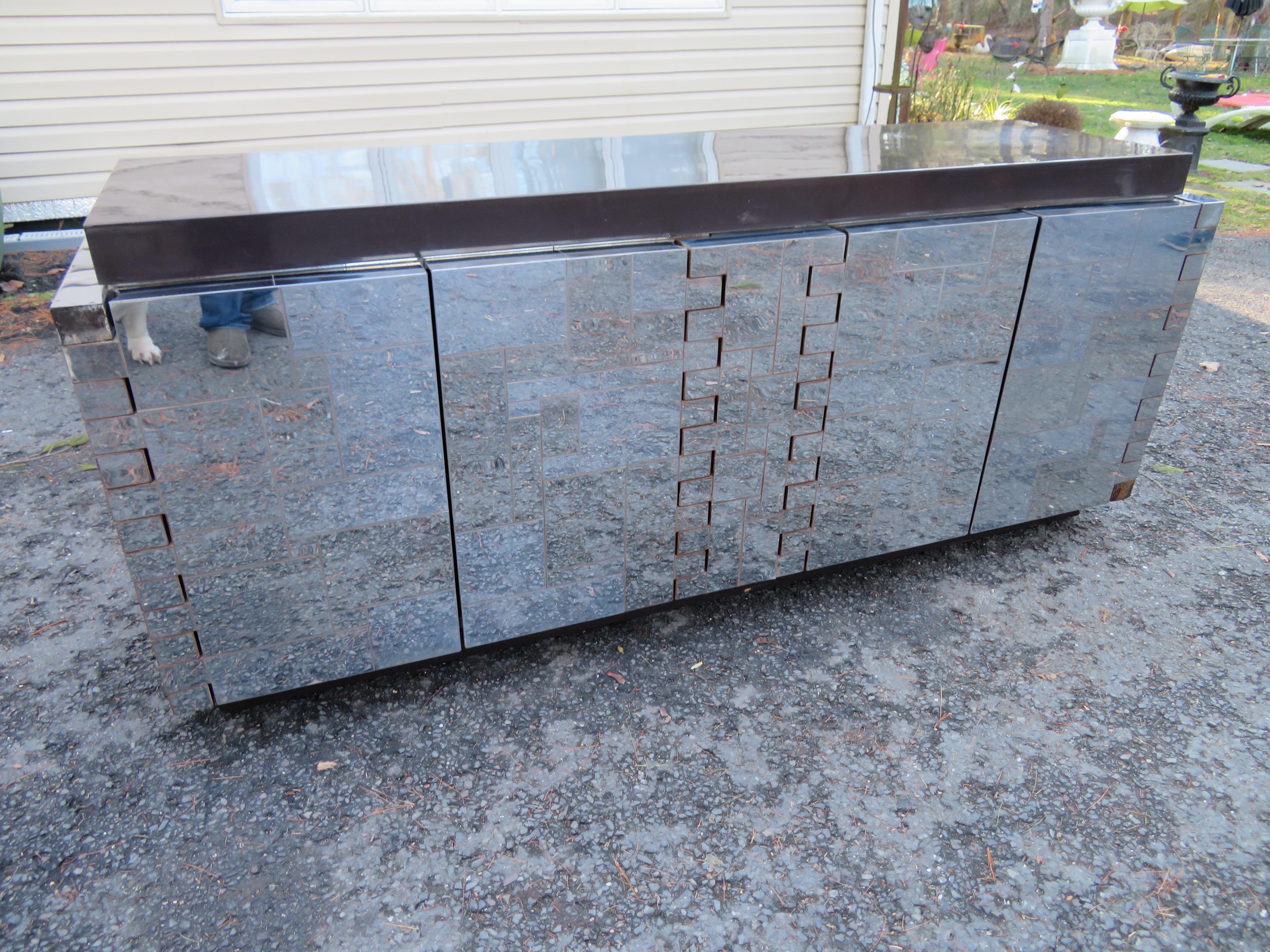 Scrumptious signed Paul Evans cityscape credenza. This piece is quite unique with the puzzle door hinges and the chocolate brown fibreglass top and plinth bottom. There is a signature patch on the inside of one of the doors. This piece is beyond