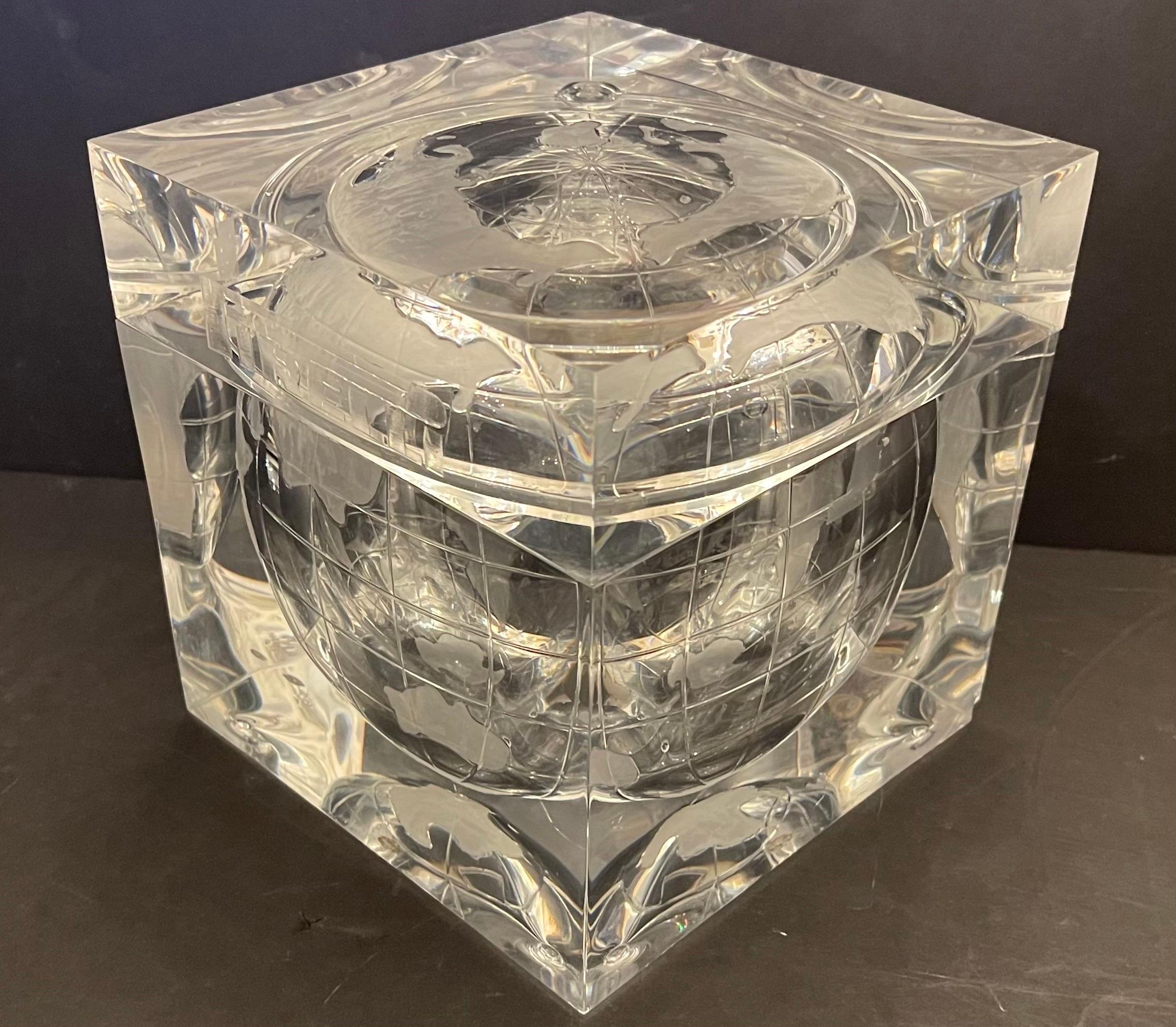 A Wonderful Heavy Lucite Ice Bucket / Cooler In The Form Of A World Globe Suspended In A Cube. The Interior Is Embossed With Earth Having Longitude And Latitude Lines. Across The Top Portion Written Pirelli
Very Small Chip In One Corner Other Then