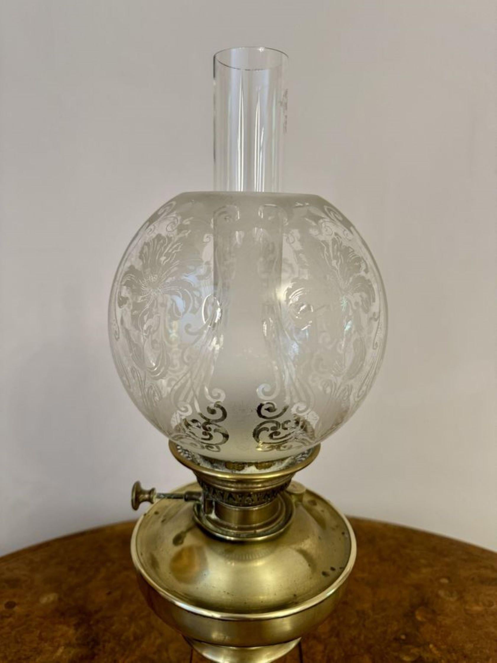 Maravillosa lámpara de aceite de latón victoriana antigua de calidad, con pantalla de globo de cristal grabado, chimenea de cristal, quemador único y columna de latón que se alza sobre una base de forma circular.

D. 1880