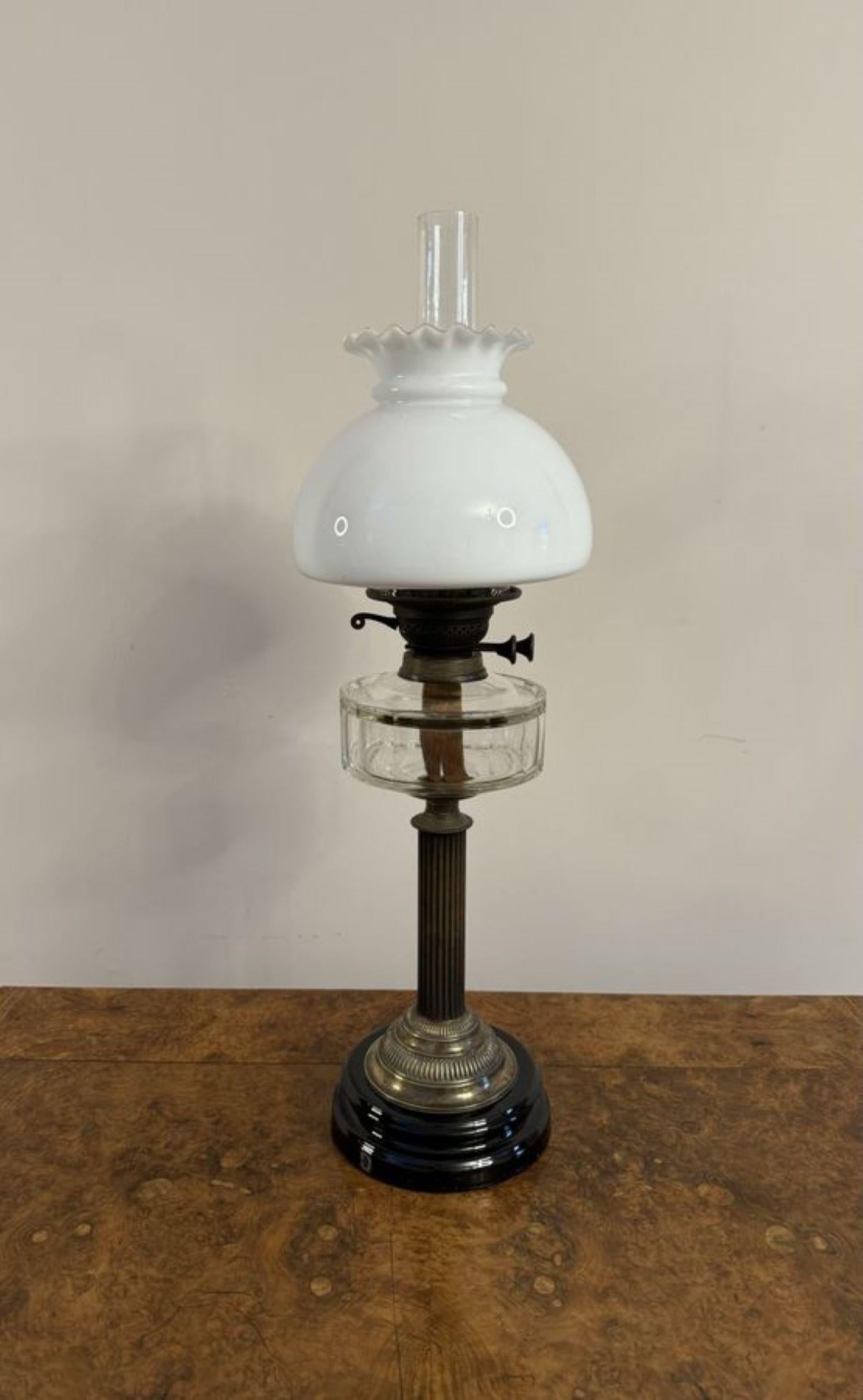 Wonderful quality antique Victorian oil lamp, having the original opaque glass shade with a frilled rim, a glass chimney, above a brass burner and clear glass font, supported by a wooden column above a brass base, raised on a black glazed circular