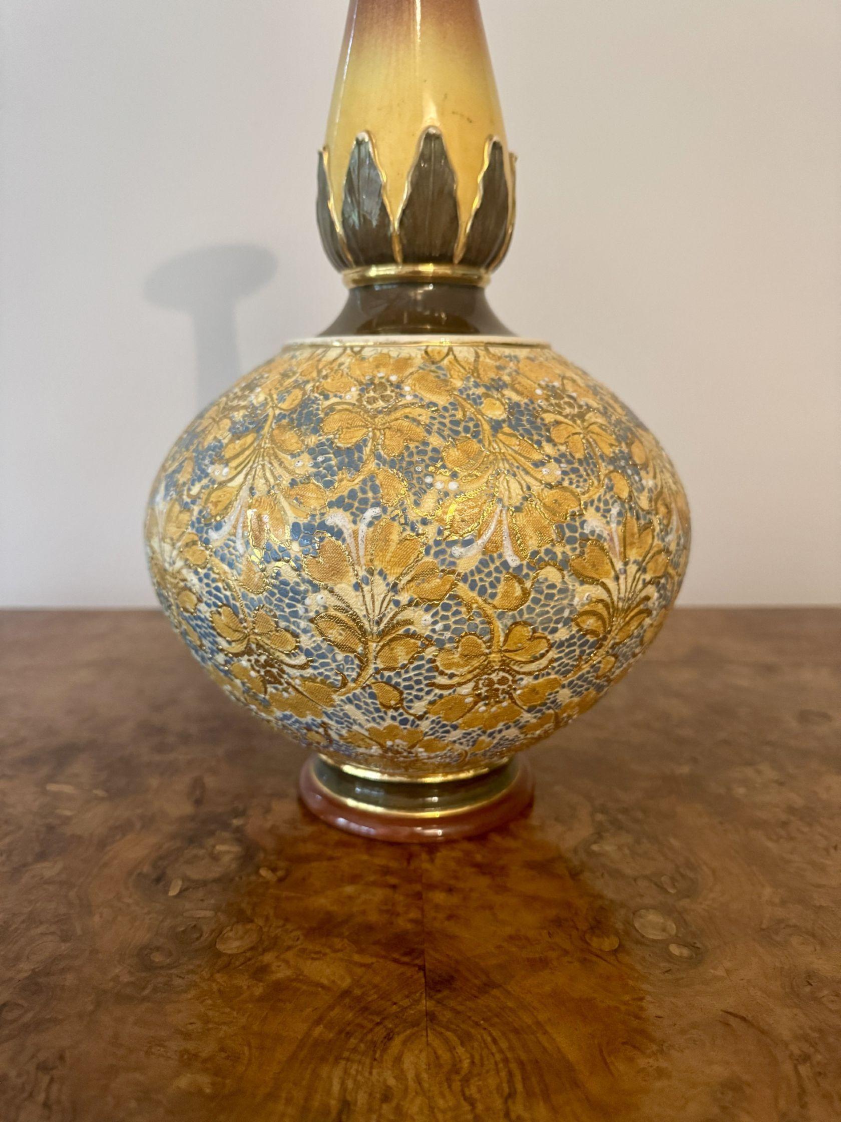 Splendido vaso Doulton antico di grandi dimensioni, con il corpo inferiore a forma di bulbo decorato con dettagli floreali in rilievo nei colori dell'oro e del blu su un fondo dorato, al di sotto di un collo sottile e lungo con colori sfumati dal