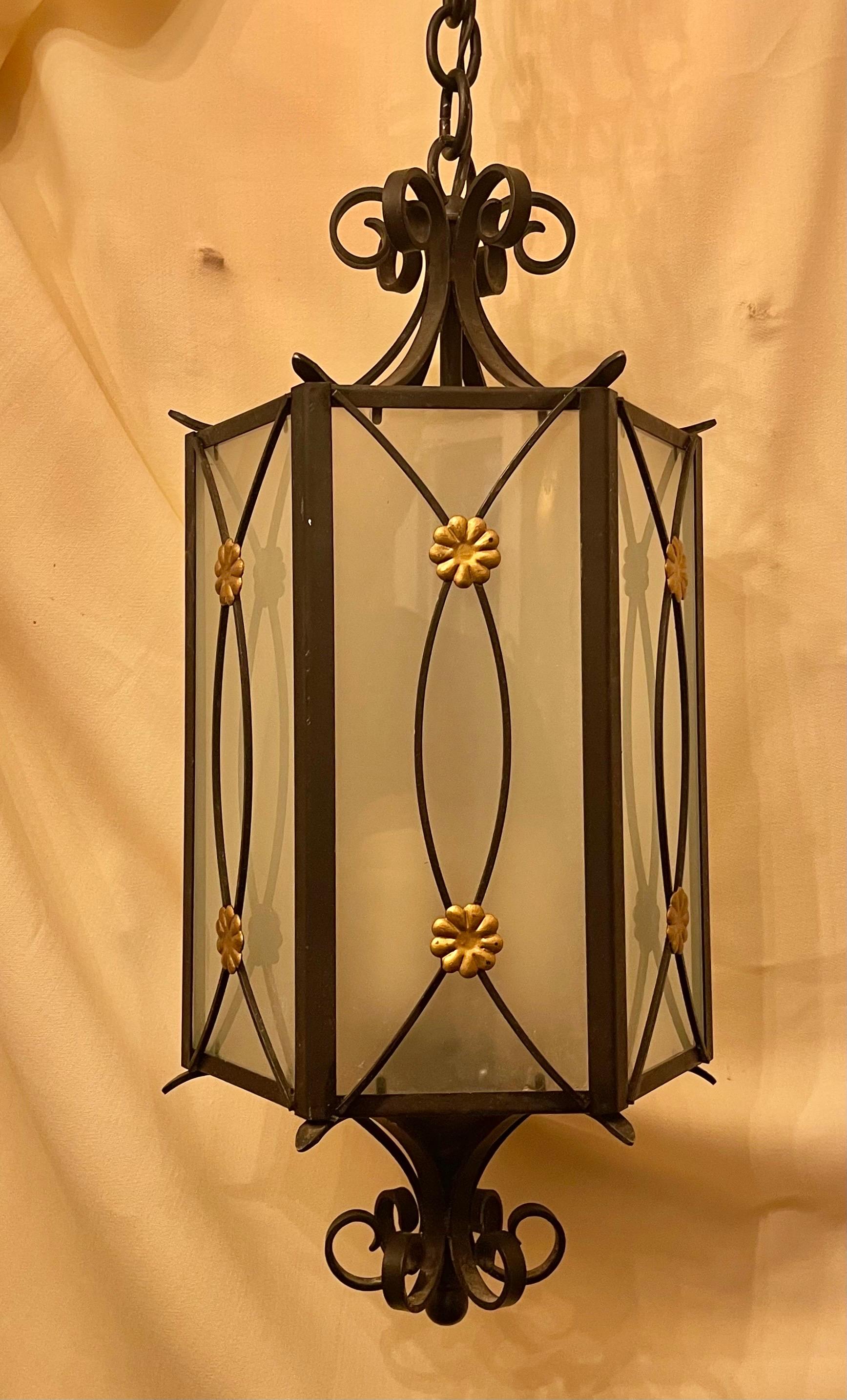 A wonderful regency iron with gold gilt flower rosette medallion with inset frosted glass panel hexagon hexagon shaped lantern fixture with 3 interior candelabra sockets.