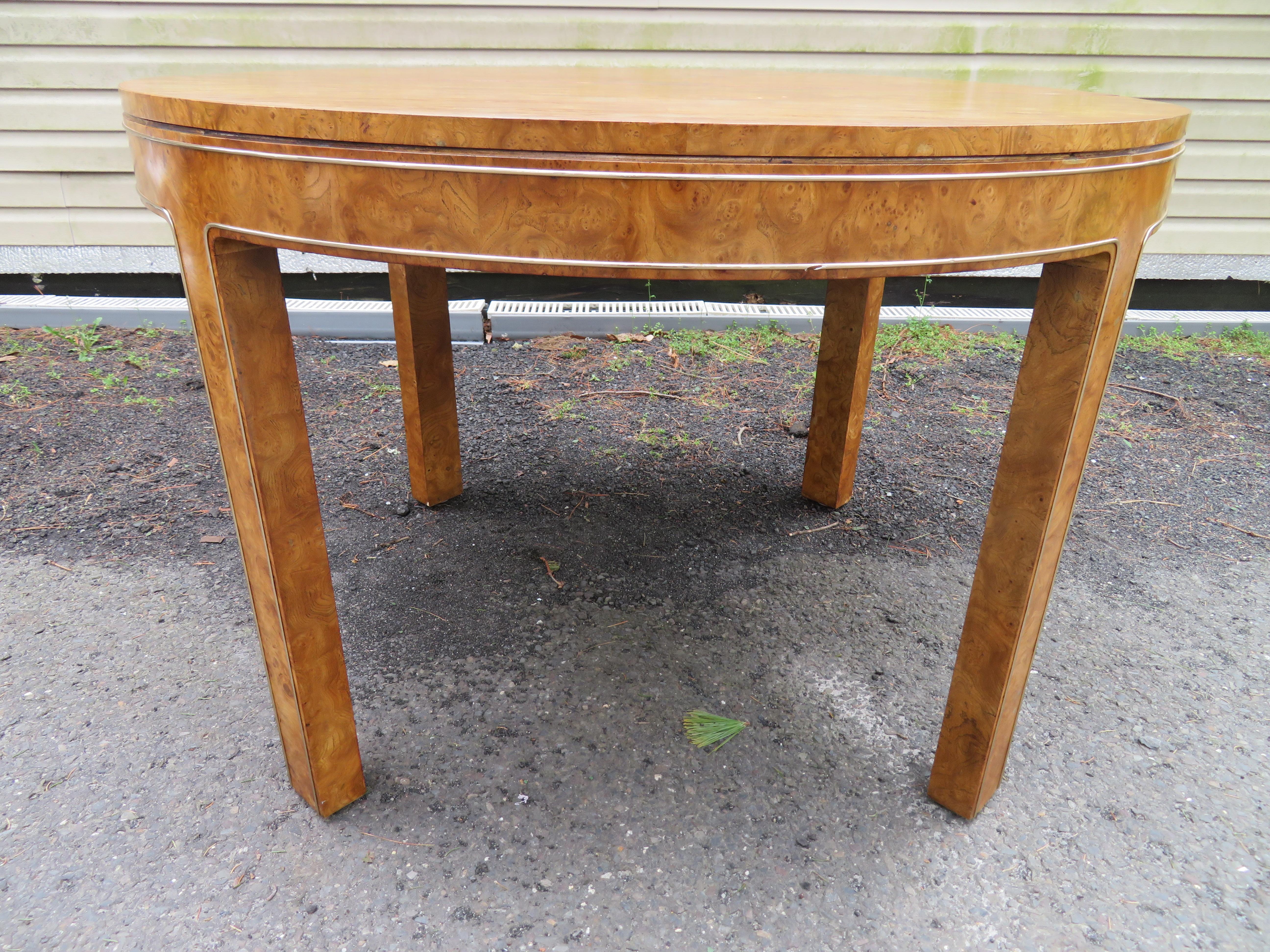 Wonderful round Mastercraft burled dining table with 2 leaves. We love the petite size and brass detailing on the sides and down the legs. This table measures 29.75