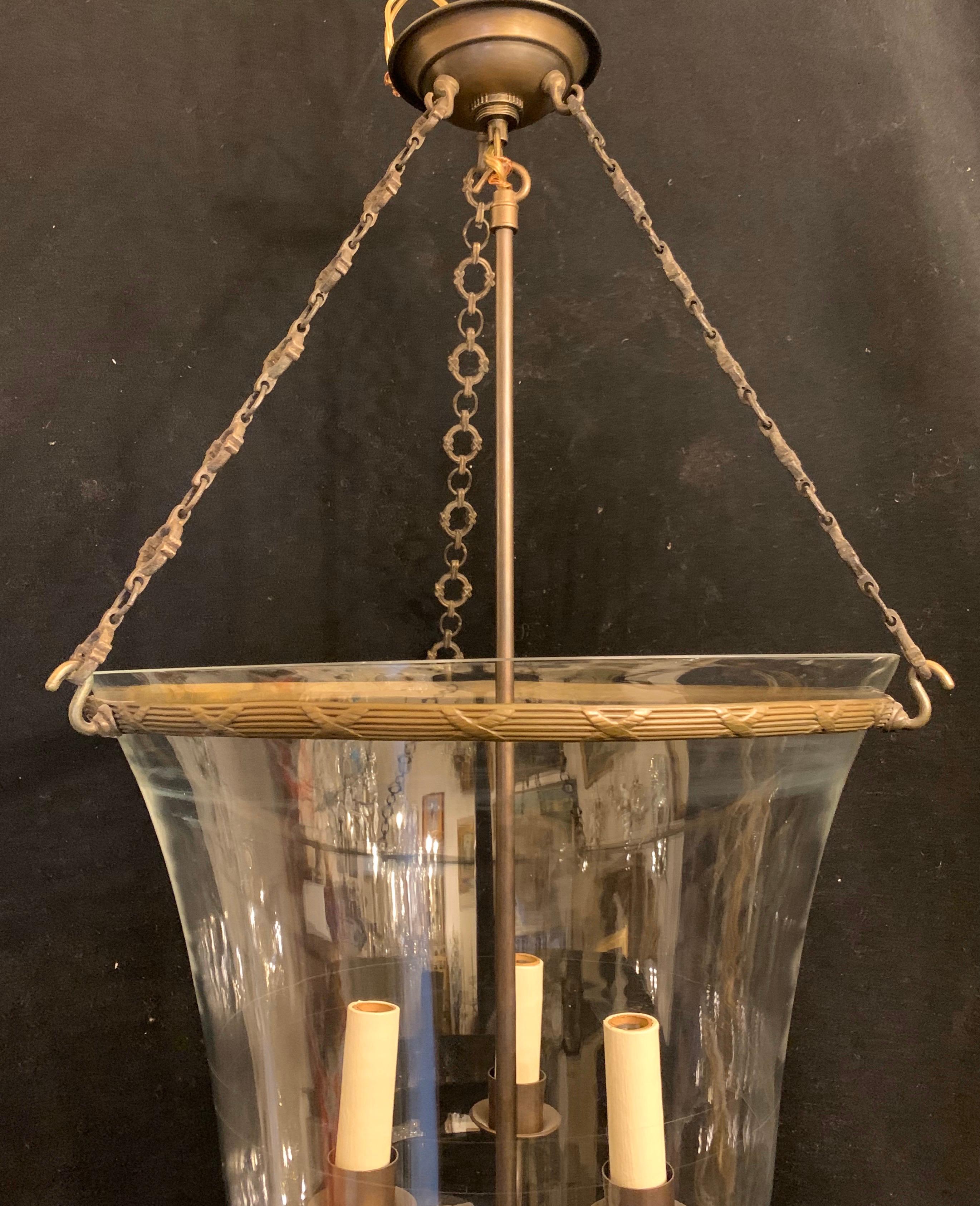 A wonderful large Vaughan glass globe bell jar lantern, rewired with candelabra sockets and has a bronze ribbon and reed rim leading to three decorative chains.

