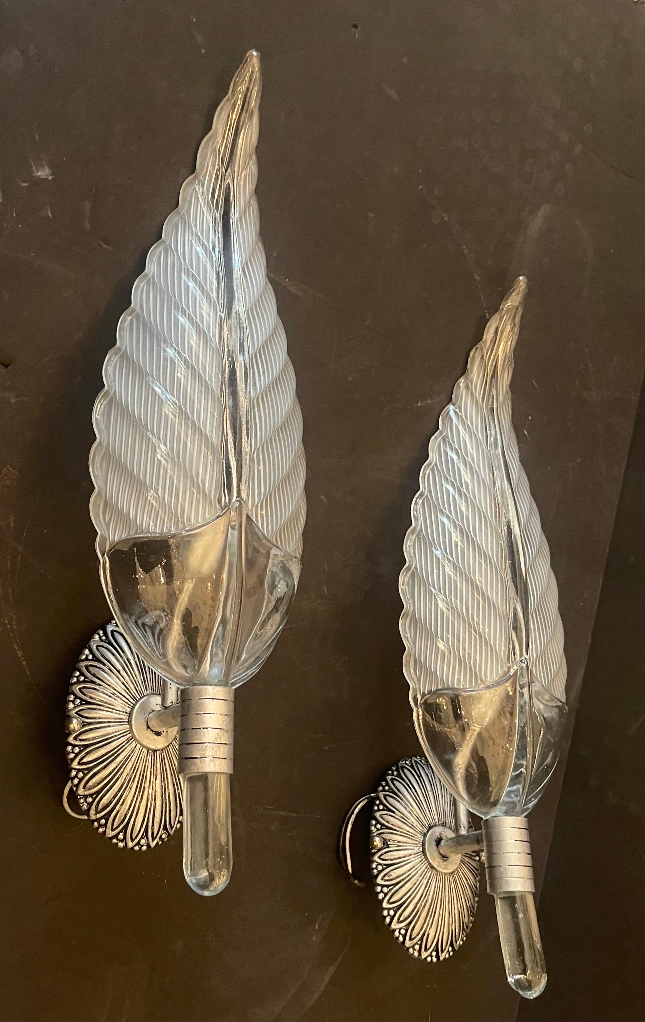 A Wonderful Set Of 4 Mid Century Modern Murano Sconces In The Manner Of  Barovier & Toso. With A Stunning Glass Shade In The Form Of A Large Leaf Shape And Having An Oval Nickel Plated Back Plate Leading To A Single Candelabra Socket. 

2 Pairs