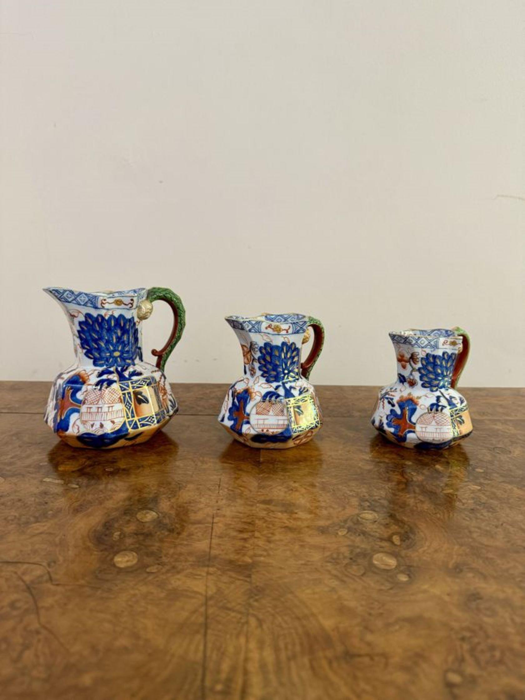 Merveilleux ensemble de trois cruches octogonales antiques Davenport en pierre de fer, de taille graduée, chacune dotée d'un large bec verseur, d'une anse en forme d'hydre à l'arrière et d'un corps à facettes, décorées d'une profusion de fleurs, de