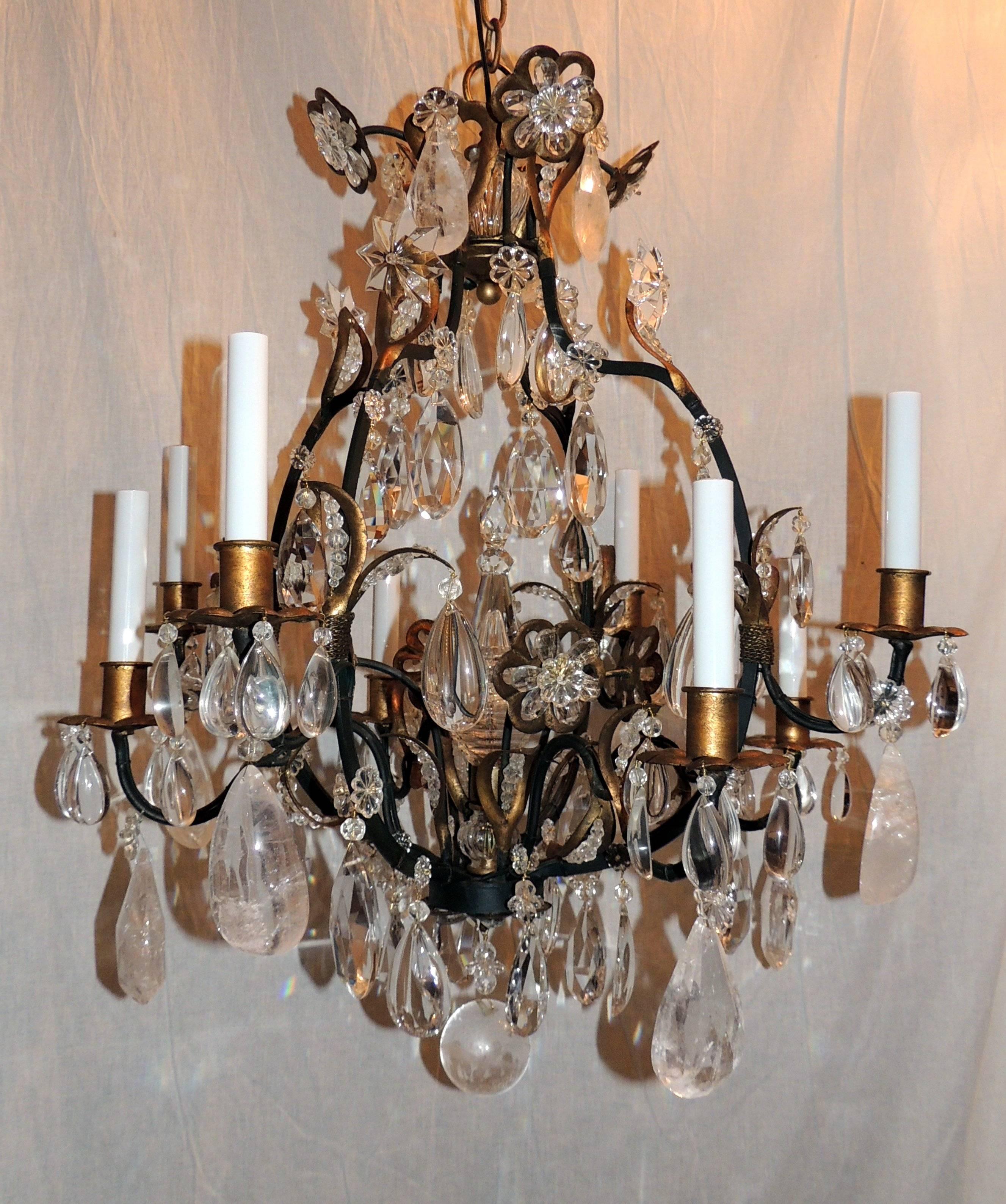 A lovely set of three French iron & rock crystal chandeliers with eight lights in the manner / style of Maison Baguès.
The details: beaded crystals are the center of each of the leaves, rock crystal surrounds the top crystal flowers and throughout