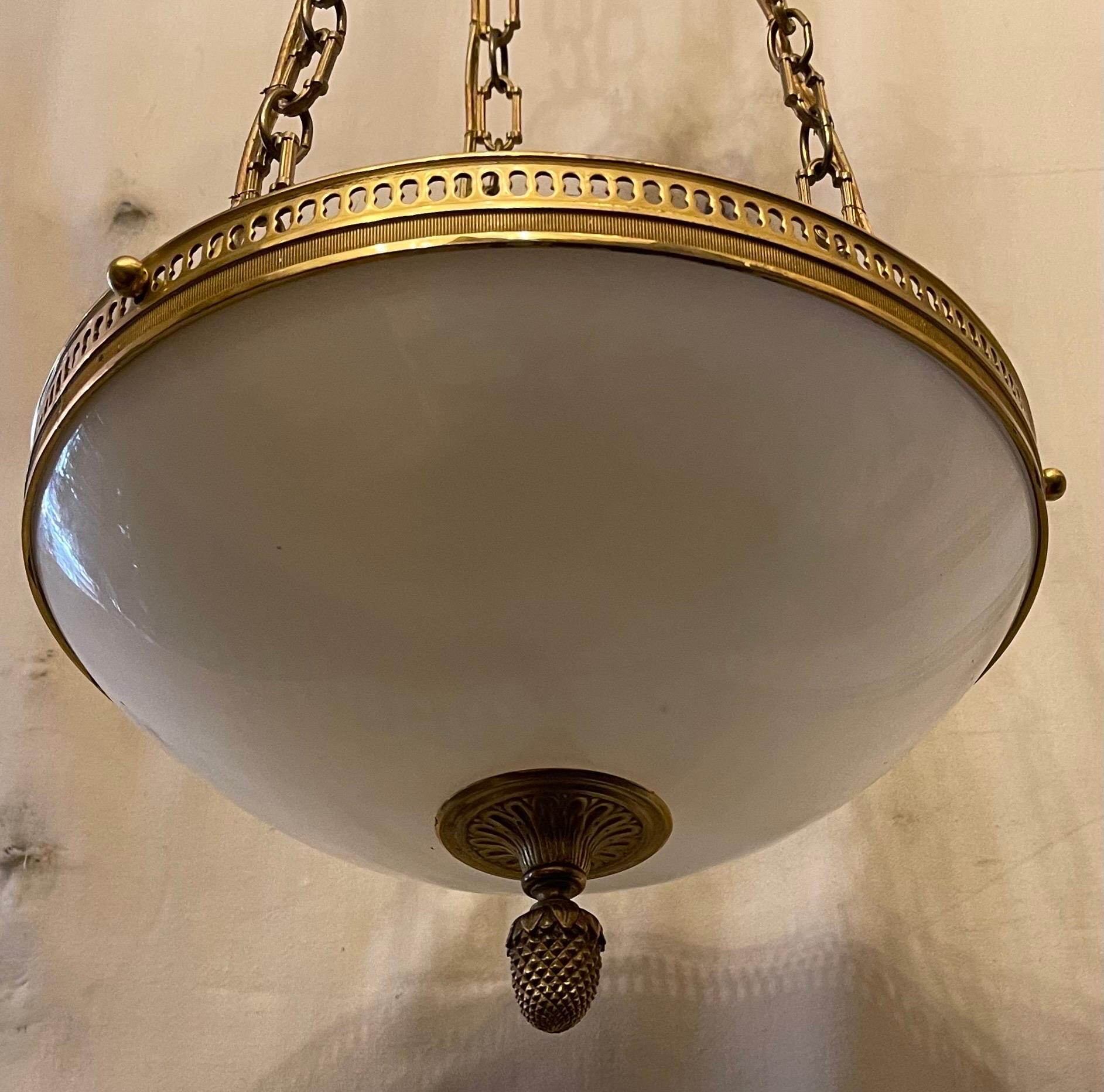A wonderful Sherle Wagner style vaughan designs dore bronze with white opaline glass bowl chandelier with 3 candelabra sockets.
This fixture can be shortened to your needs by easily removing chain links.