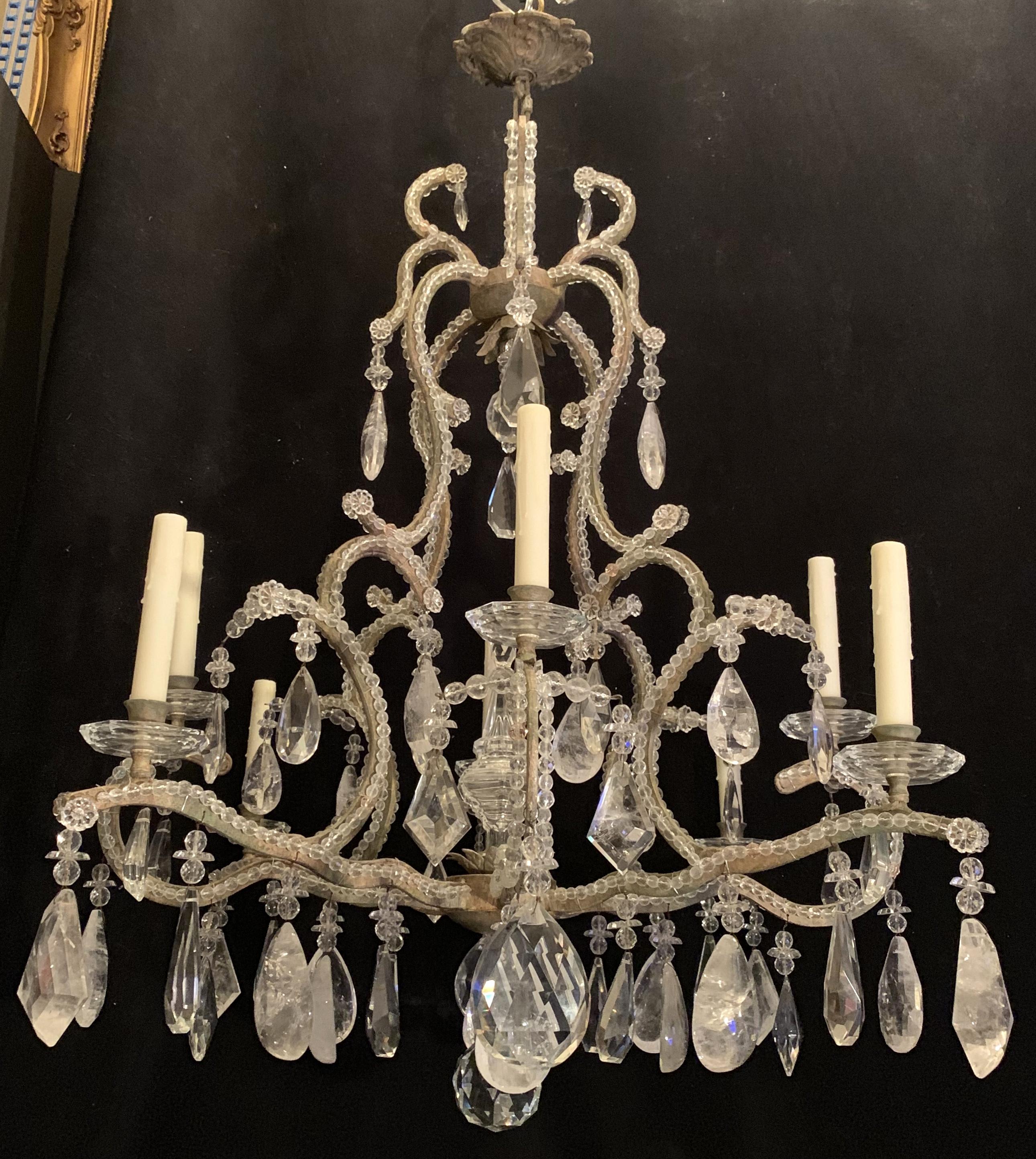 A wonderful large 8 candelabra light chandelier with crystal beaded trim and rock crystal prisms and pendants. A center prism ball and large finial accent the center of this chandelier.
Wiring is up to date and is accompanied by chain and canopy
