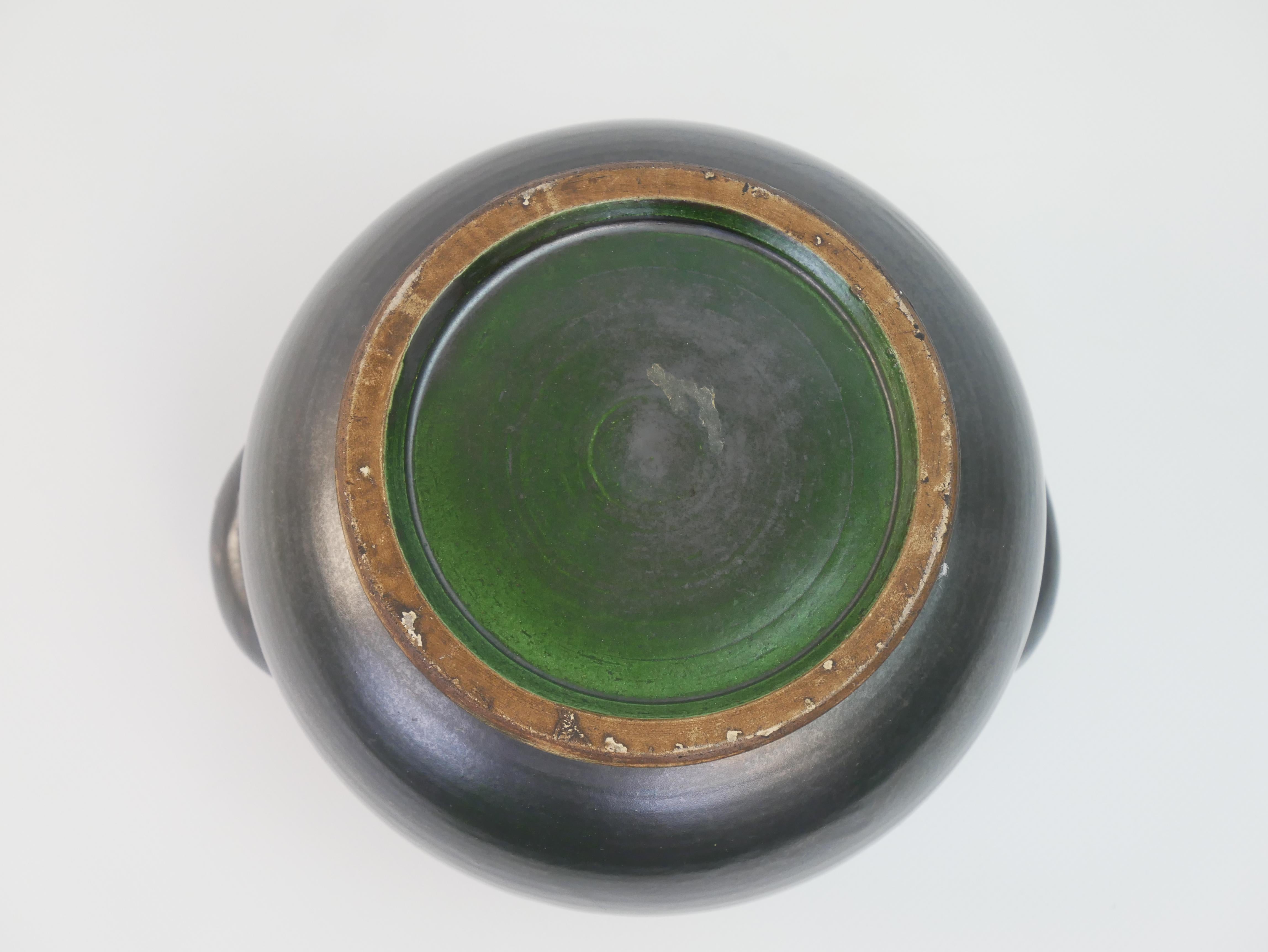 This is a sleek, handcrafted black ceramic vase attributed to Suzanne Ramié for Madoura Vallauris. The vase features a rounded, minimalist design with two symmetrical side handles and a slightly flared rim. Its glossy black exterior contrasts