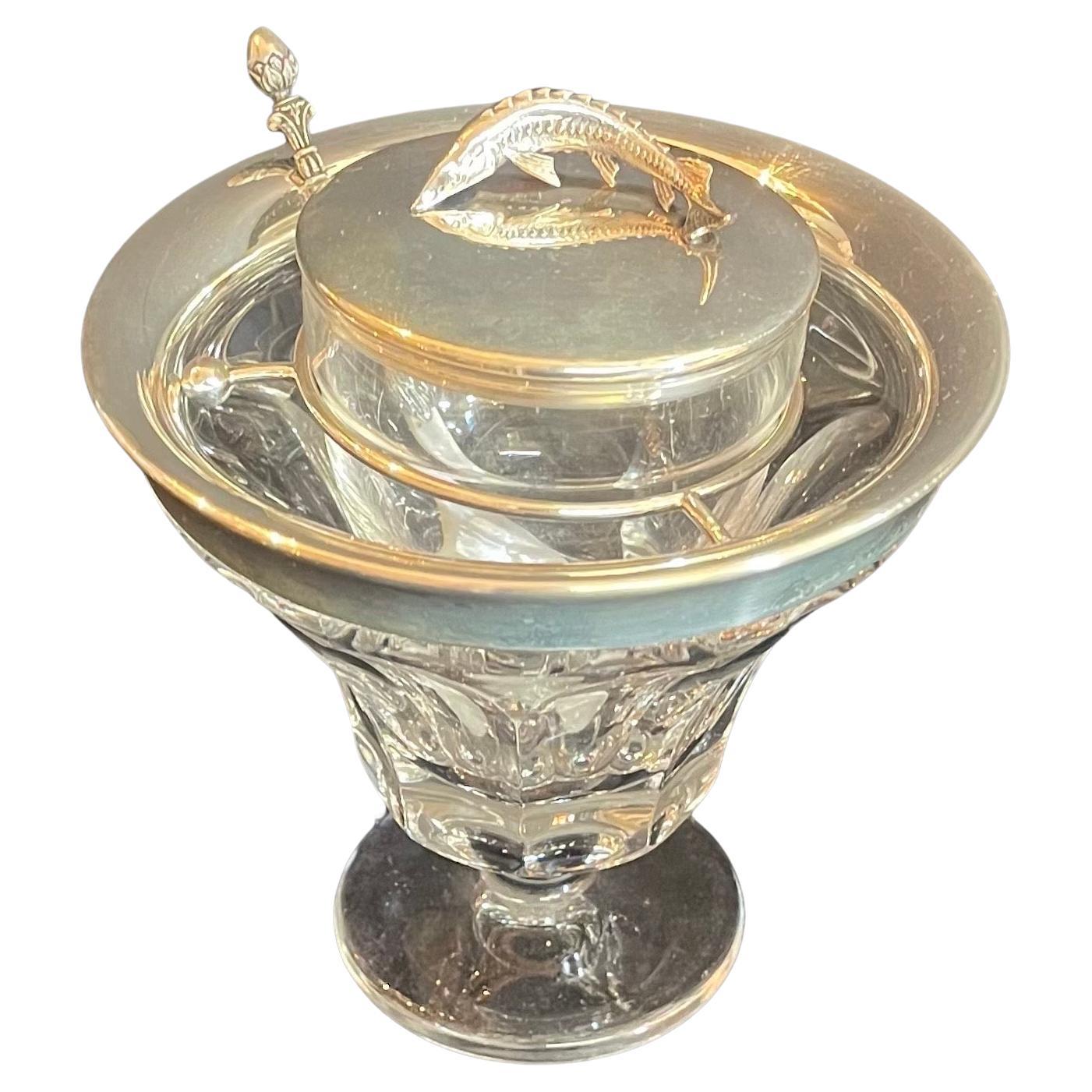 A wonderful entertaining piece by the re known firm of Asprey of London. The finial is of finely chased sterling silver sturgeon beluga. The top rim of the caviar server as well as the glass holder in sterling with a  beautiful clear cut crystal
