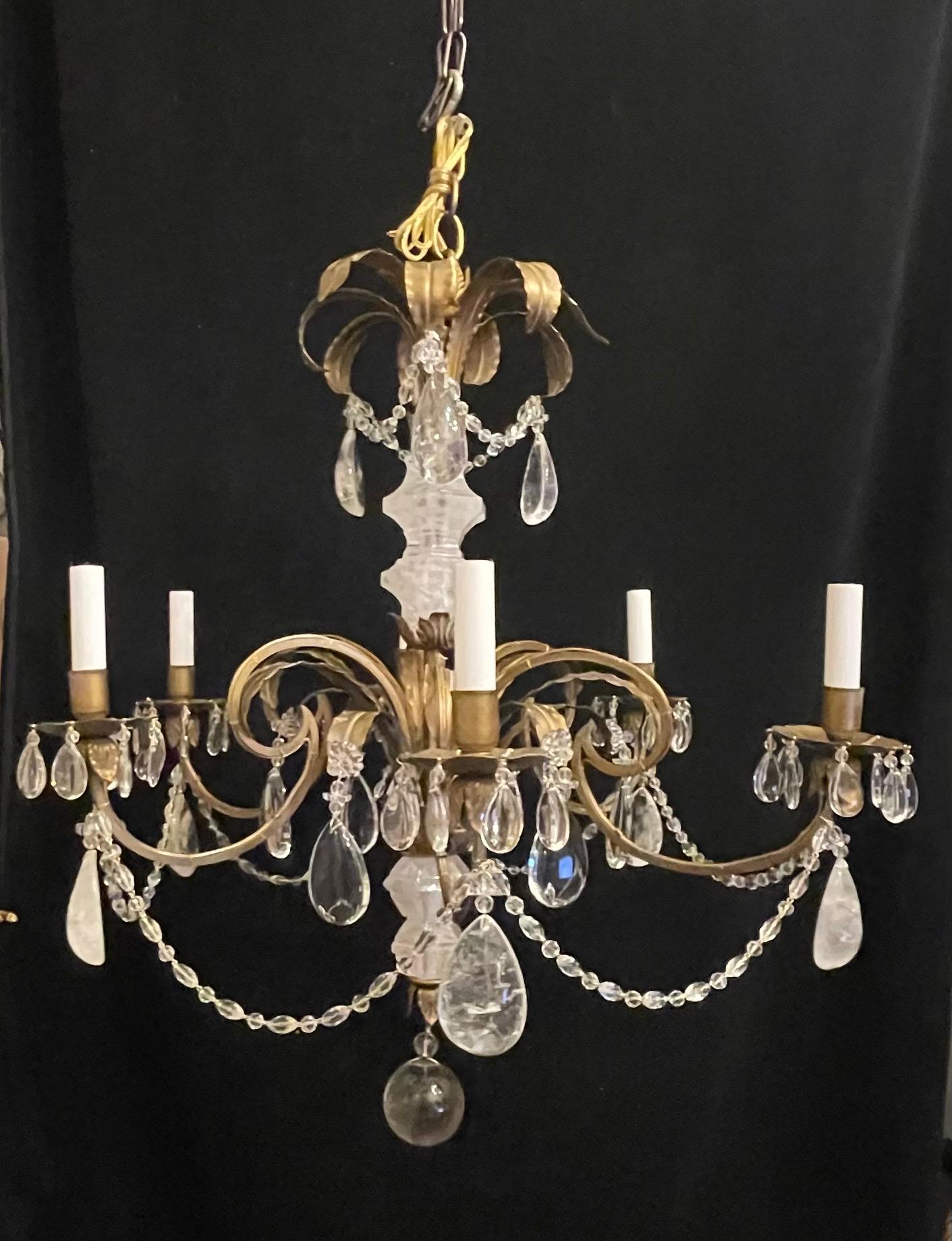 Un meraviglioso lampadario a 6 luci a candelabro in ottone dorato con albero centrale e gocce di cristallo di rocca in stile Baguès e accenti floreali alternati a perline.
