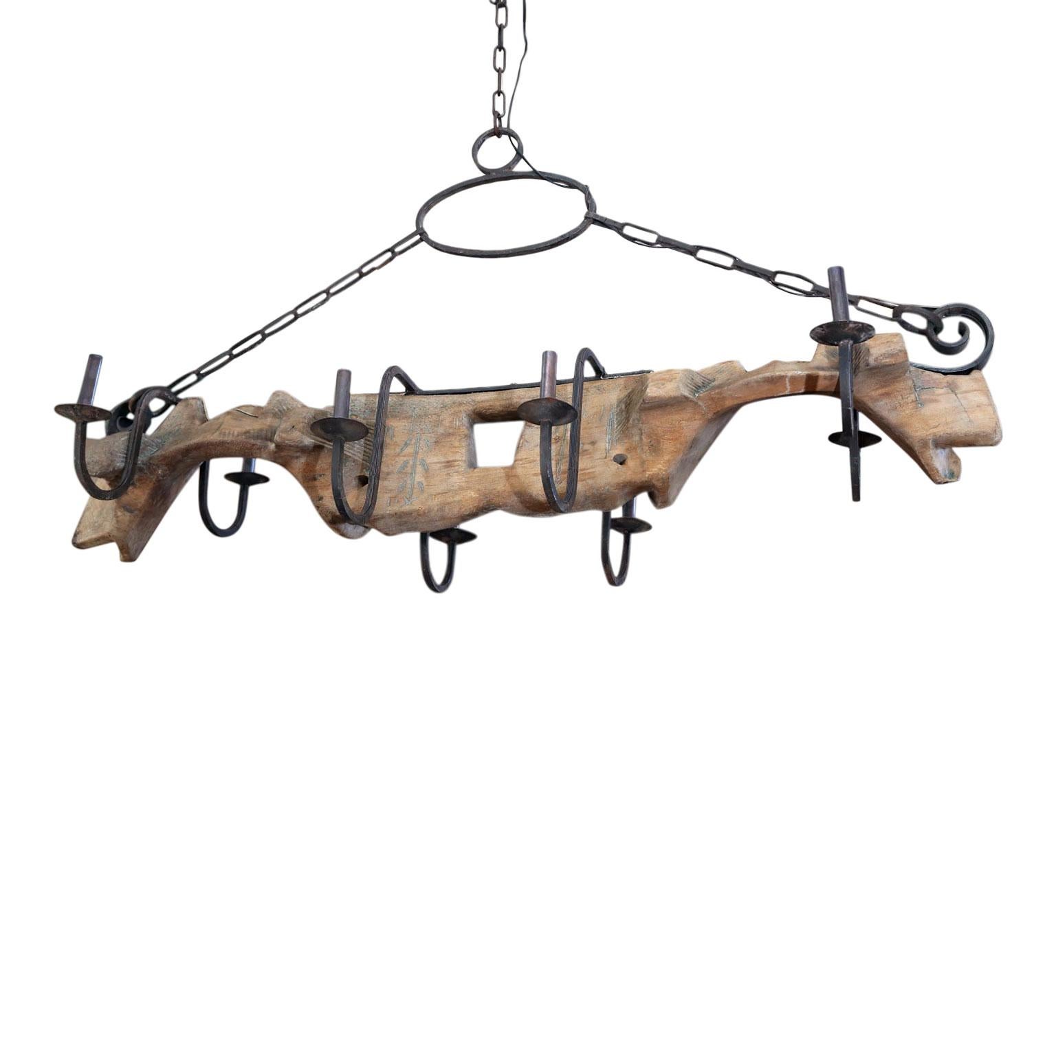 Wonderful vintage French yoke chandelier: made from circa 1900 hand-carved oxen yoke. Altered into a chandelier in the 1950s with the additional of forged iron arms. Delightful early hand painted decoration adorns its wooden surface. Perfect for