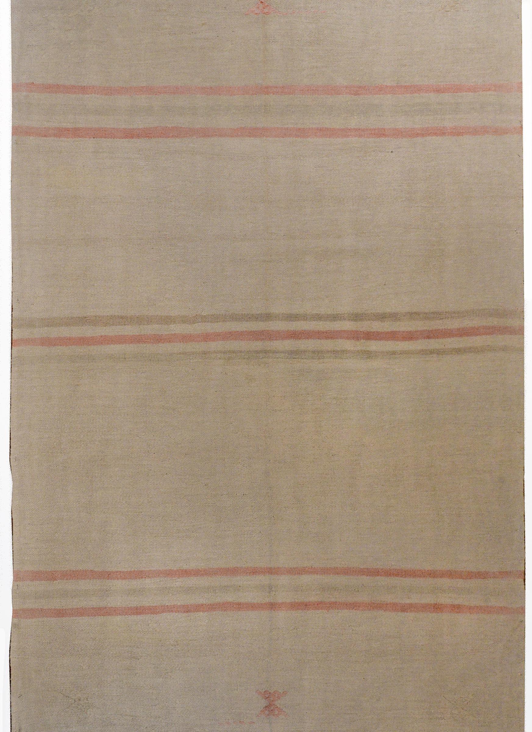 A wonderful mid-20th century Turkish Konya cotton kilim rug with a simple pattern of stylized flowers and stripes woven in pale crimson and green vegetable dyed cotton on a natural undyed cream wool background.