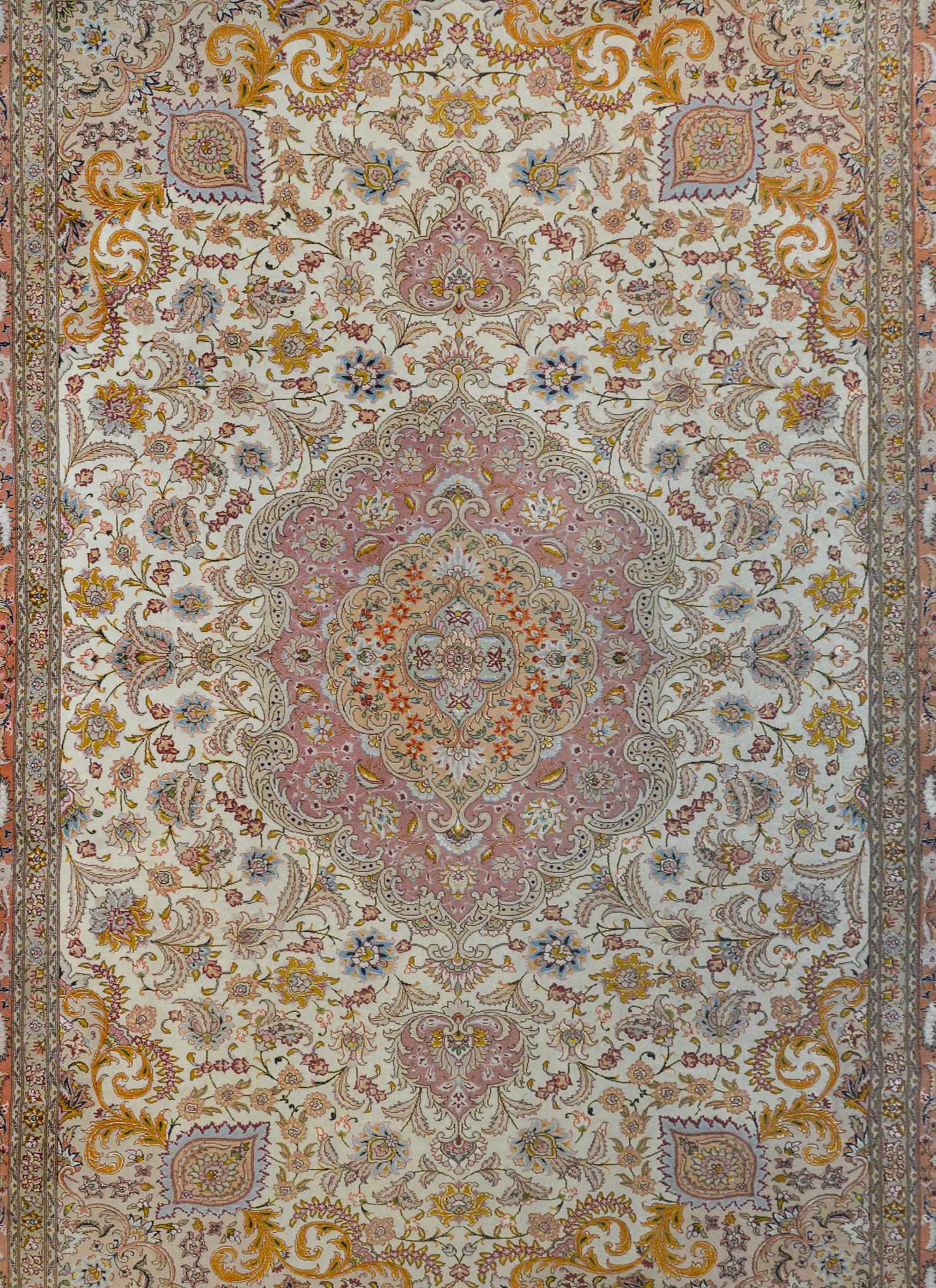A wonderful vintage Persian silk and wool Tabriz rug with a large central medallion woven in myriad flowers and vines on a lavender background, and living amidst another densely woven field of more flowers and scrolling vines, against a white
