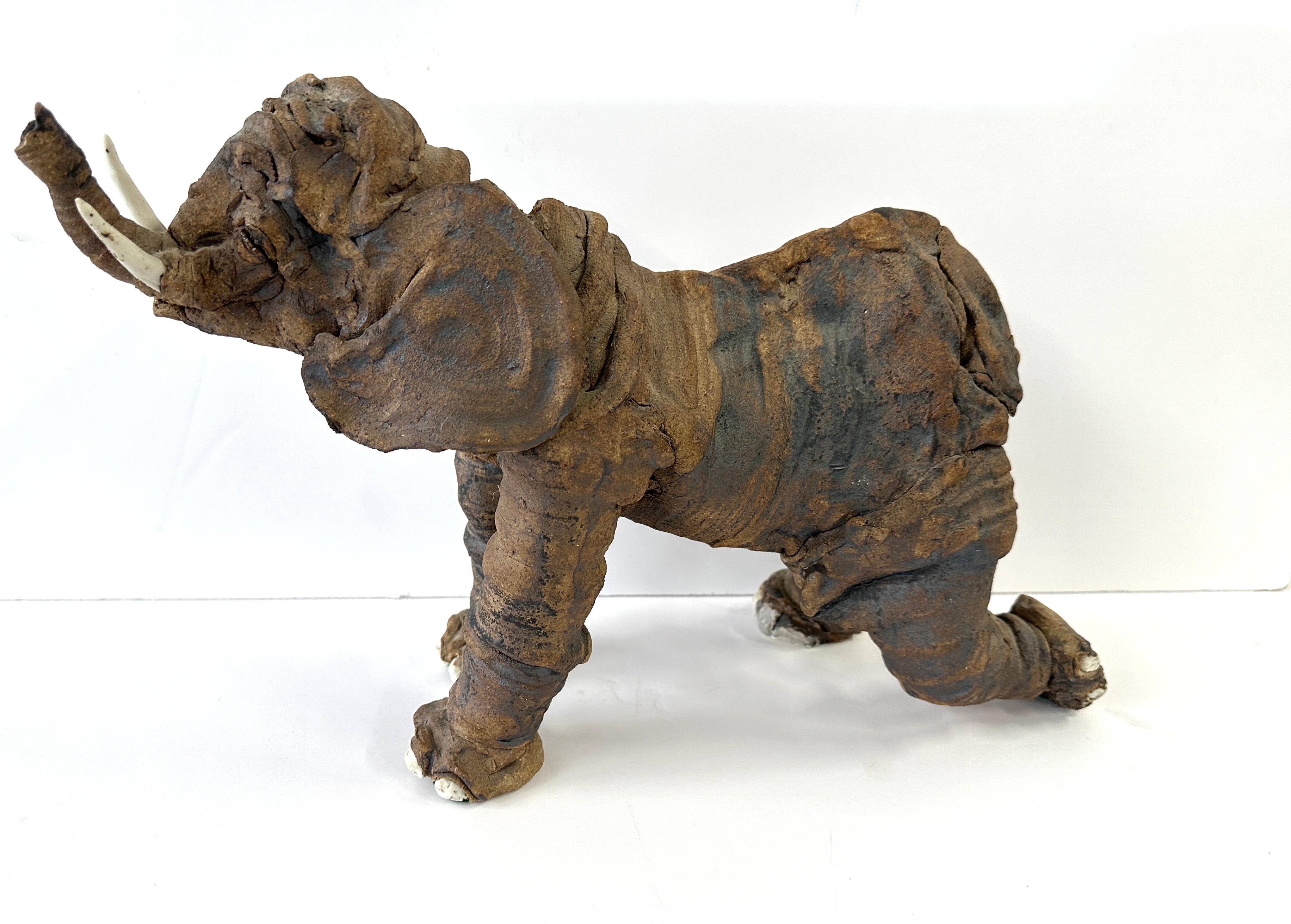 A wonderful whimsical Elephant. It is hand built of terracotta with white clay tusks and toes. Not signed or any indication of origin, but out of a local Palm Springs estate. It’s in good condition but there appears to be a old repair to one foot,