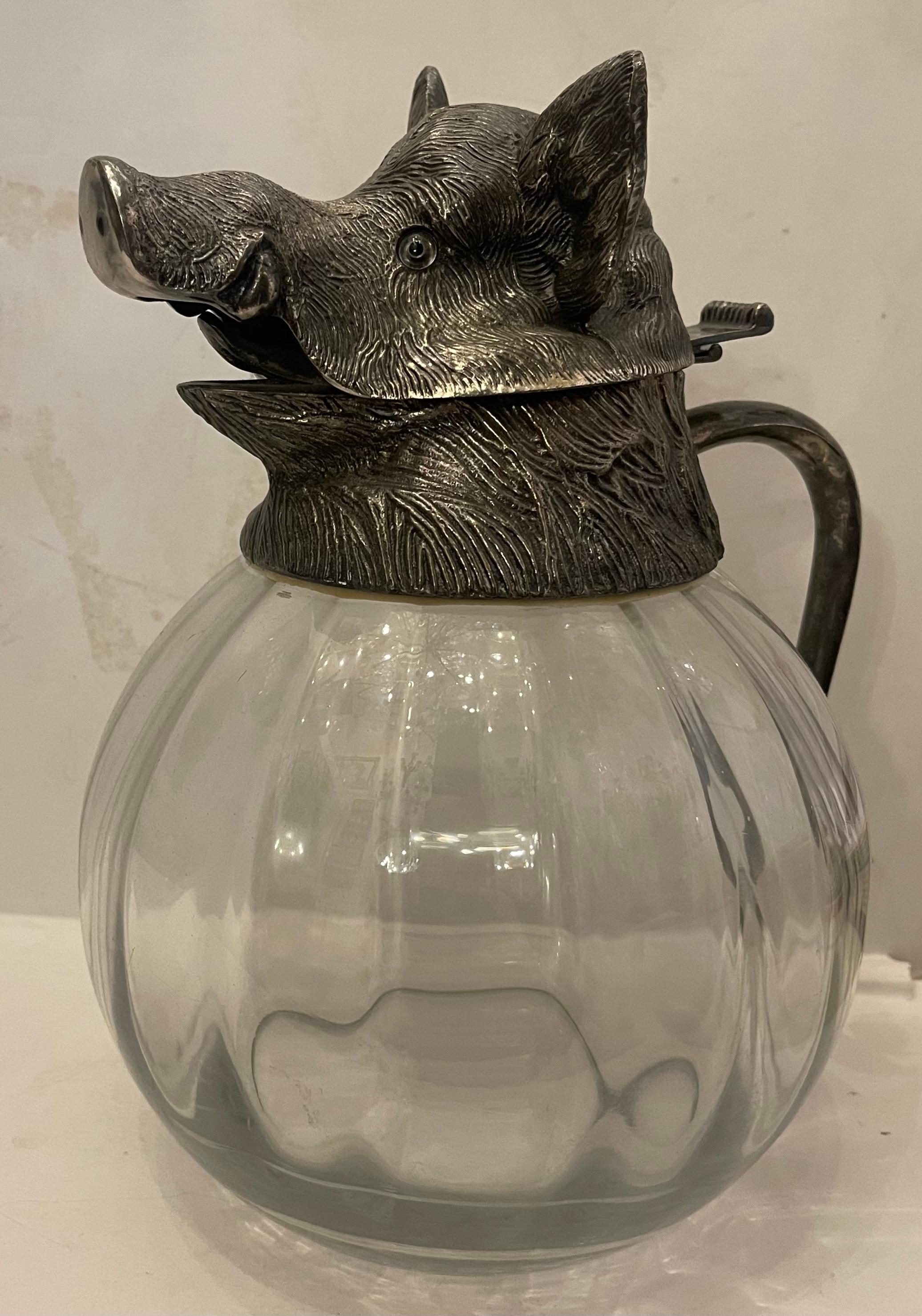 Una rara e imponente brocca spagnola di grandi dimensioni realizzata in vetro artistico pesante e con un collare figurato placcato in argento e un coperchio incernierato a forma di testa di cinghiale che conserva gli occhi di vetro originali.
Queste