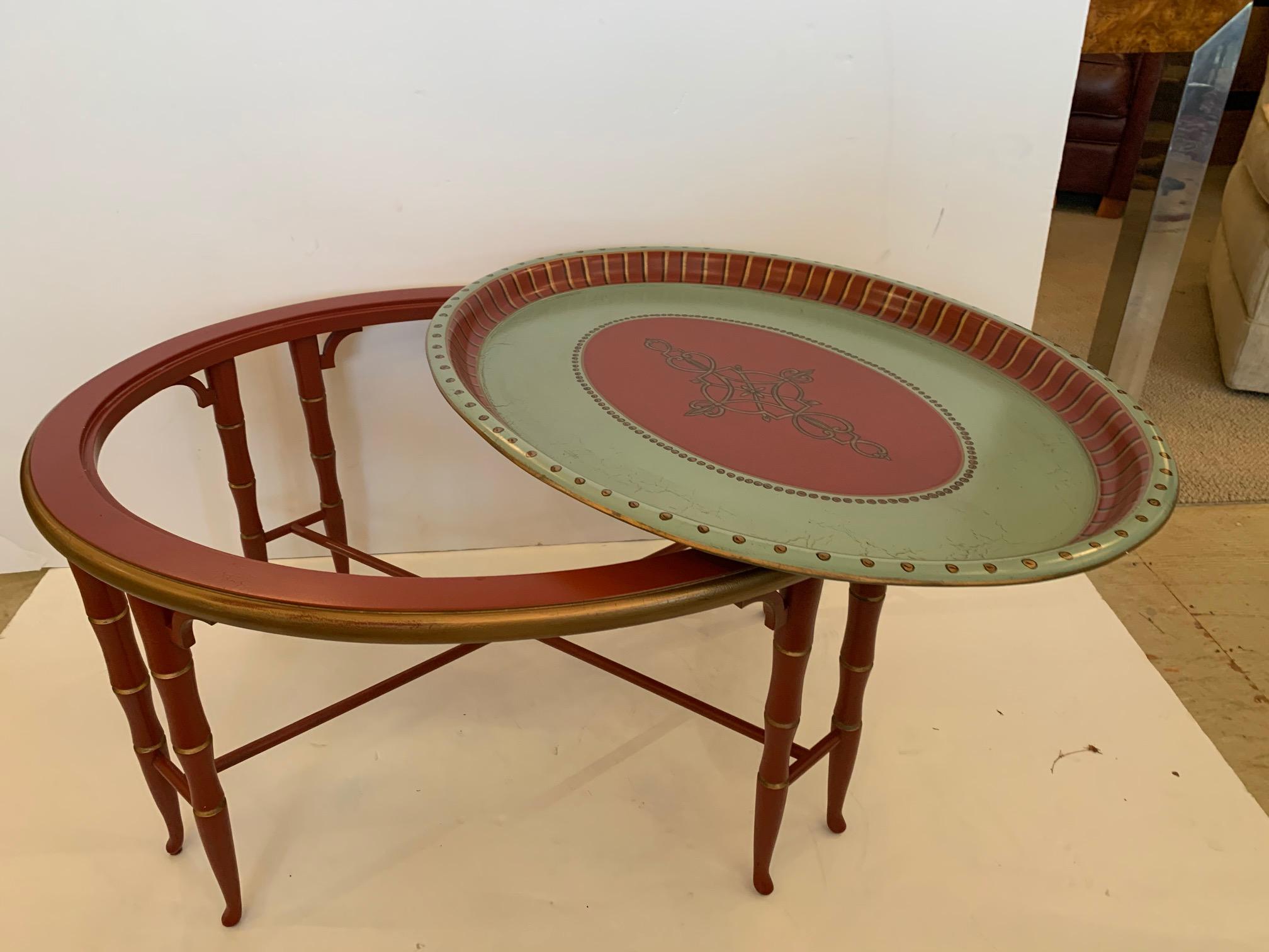 Beautiful composition and wood oval tray top coffee table having cinnabar faux bamboo base and wonderfully decorative painted tray top in sea foam green, cinnabar and gold.


   