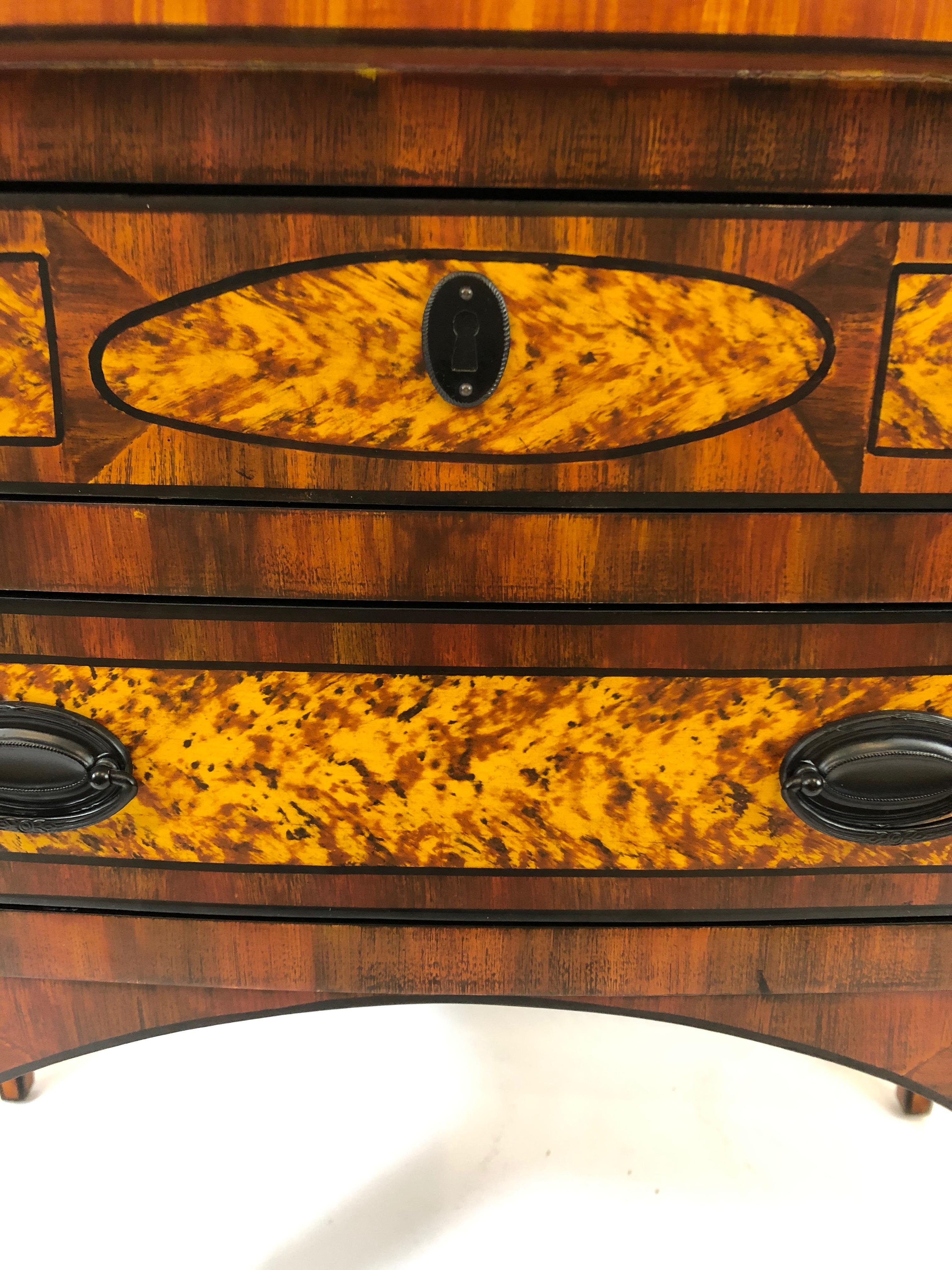 Eye-catching decorative lowboy with richly patterned grain painting that gives the impression of a mix of woods such as zebrawood, burl and ebonized accents. One long narrow drawer at the top on top of 3 smaller drawers. Handsome black hardware.