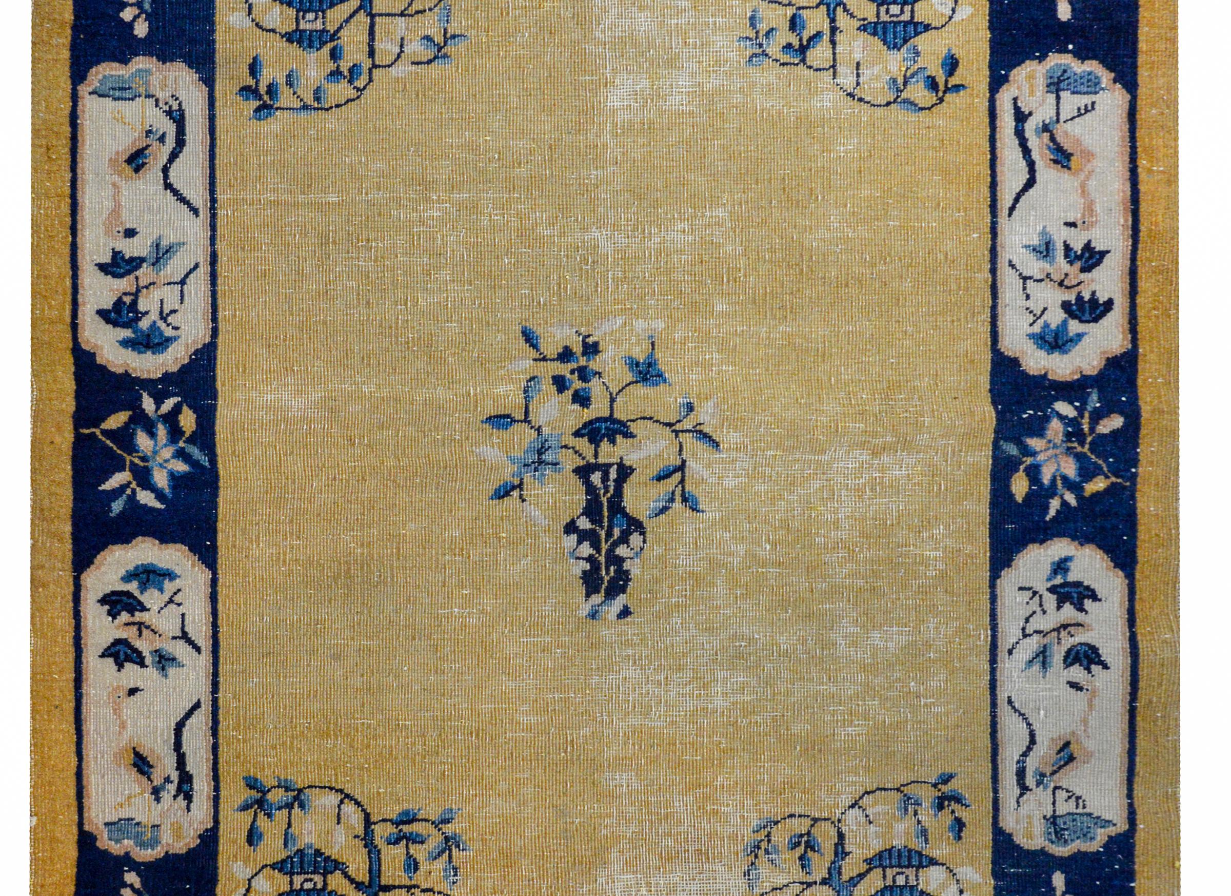 A wonderfully distressed Chinese Art Deco rug with a faded yellow field with a potted vase in the center and miniature garden pagodas under weeping willow trees in each corner. The border also contains potted vases in each corner with bird