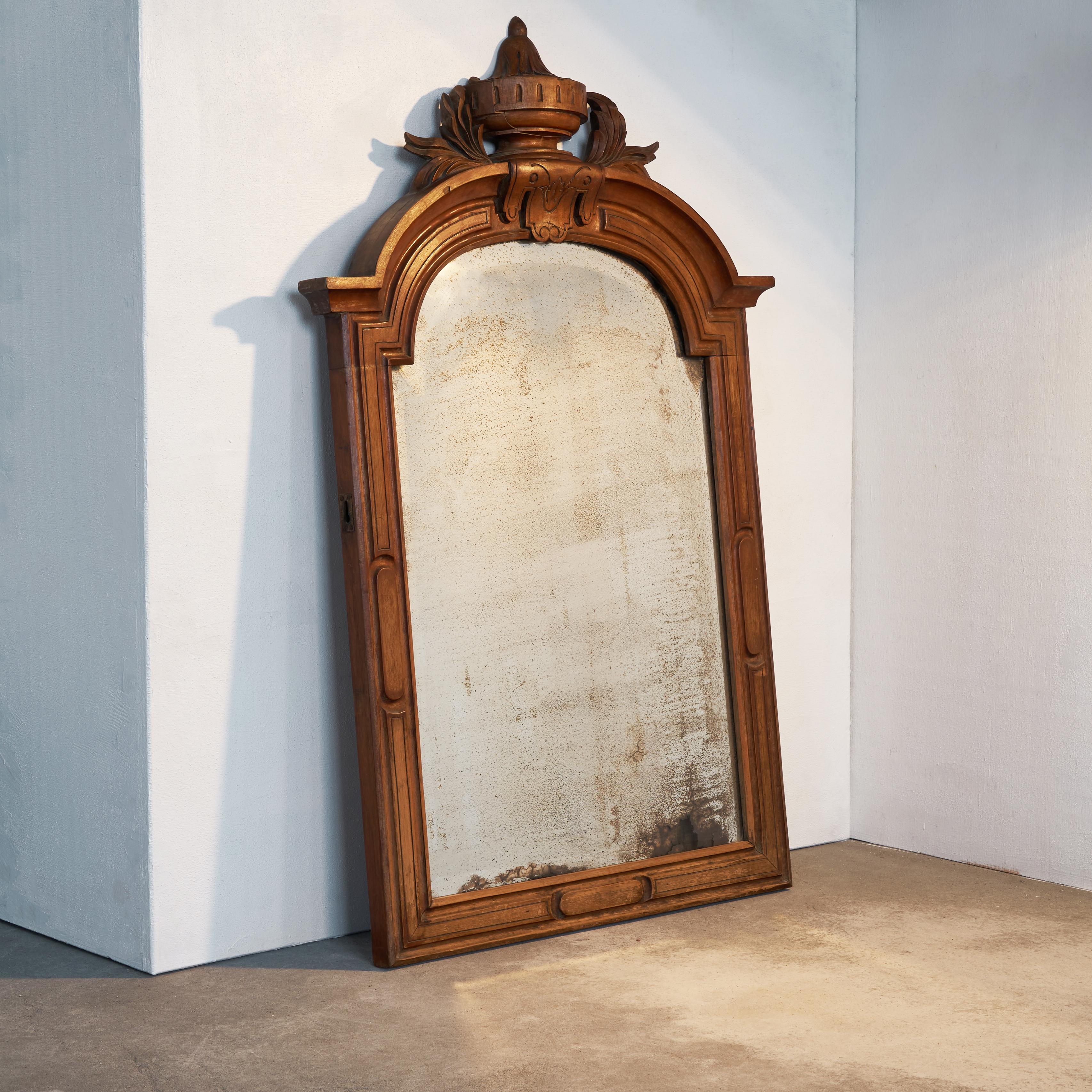 Patinated mirror in carved mahogany frame, late 19th century.

This is a very decorative mirror in a beautifully carved frame in mahogany. The stylish decoration is classic but not over the top. The most special part of this mirror is without a