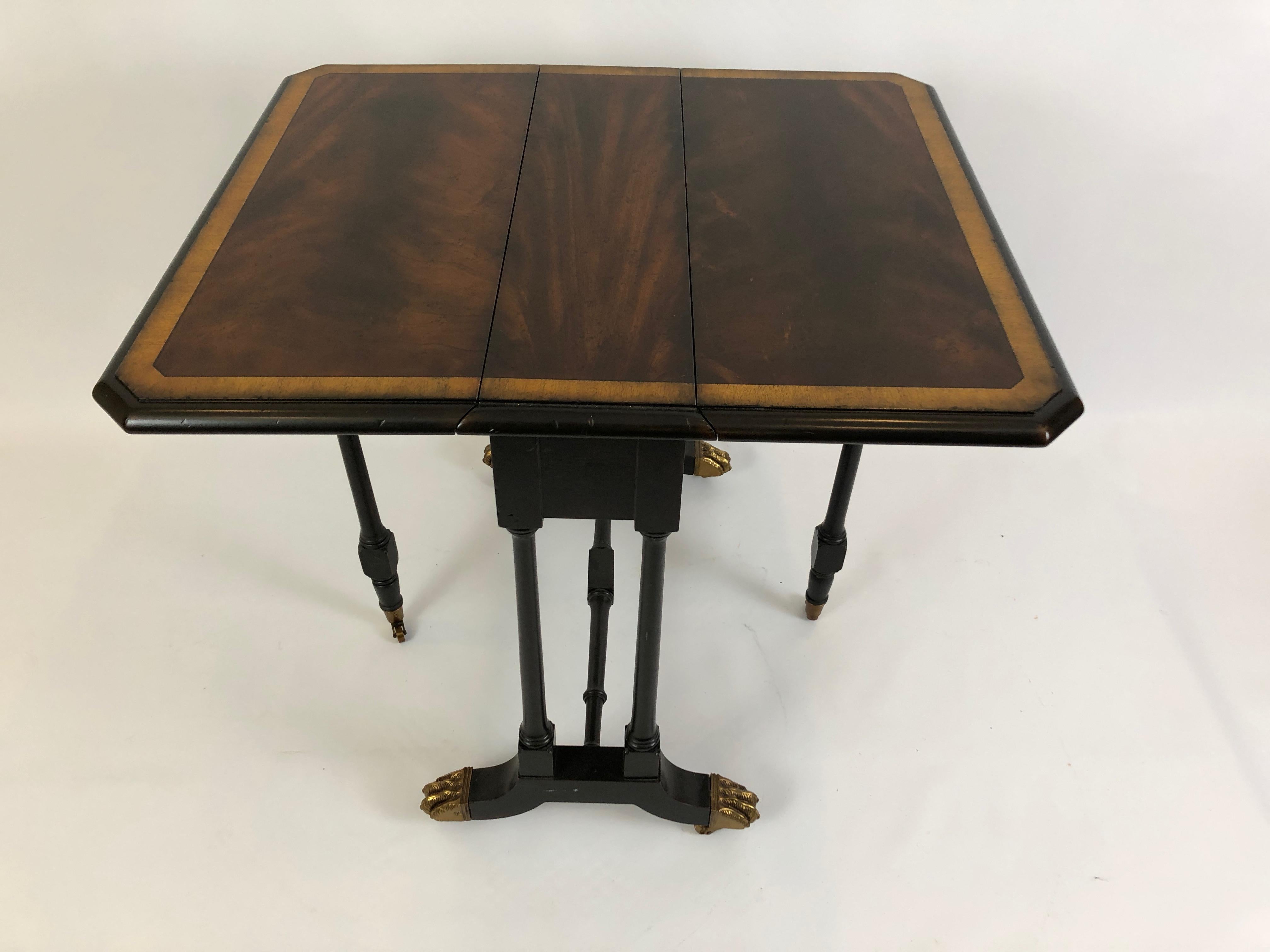 Elegant drop-leaf side or end table that's wonderfully versatile since it opens to a clipped corner rectangle table in gorgeous flame mahogany with satinwood border, and when closed it's super narrow at only 14.5 D. Pretty brass paw feet are a