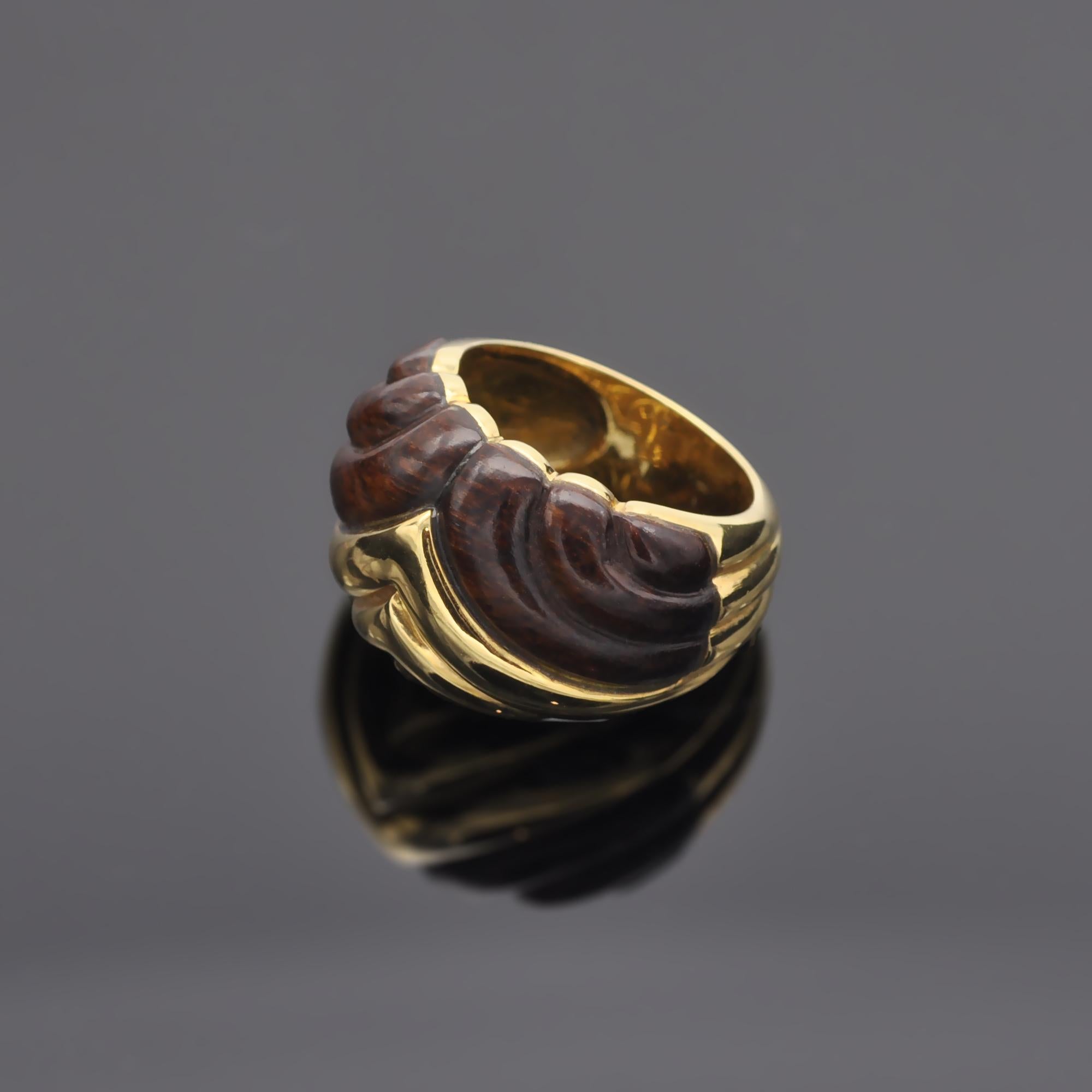 This exquisite ring is characterized by its unique marriage of carved wood and gold. Excellently crafted, a modern pattern runs seamlessly across this lovely 18kt gold ring. 
 
18kt gold, French Hallmark
width : 1,55 cm  (0.63 in) 

Matching