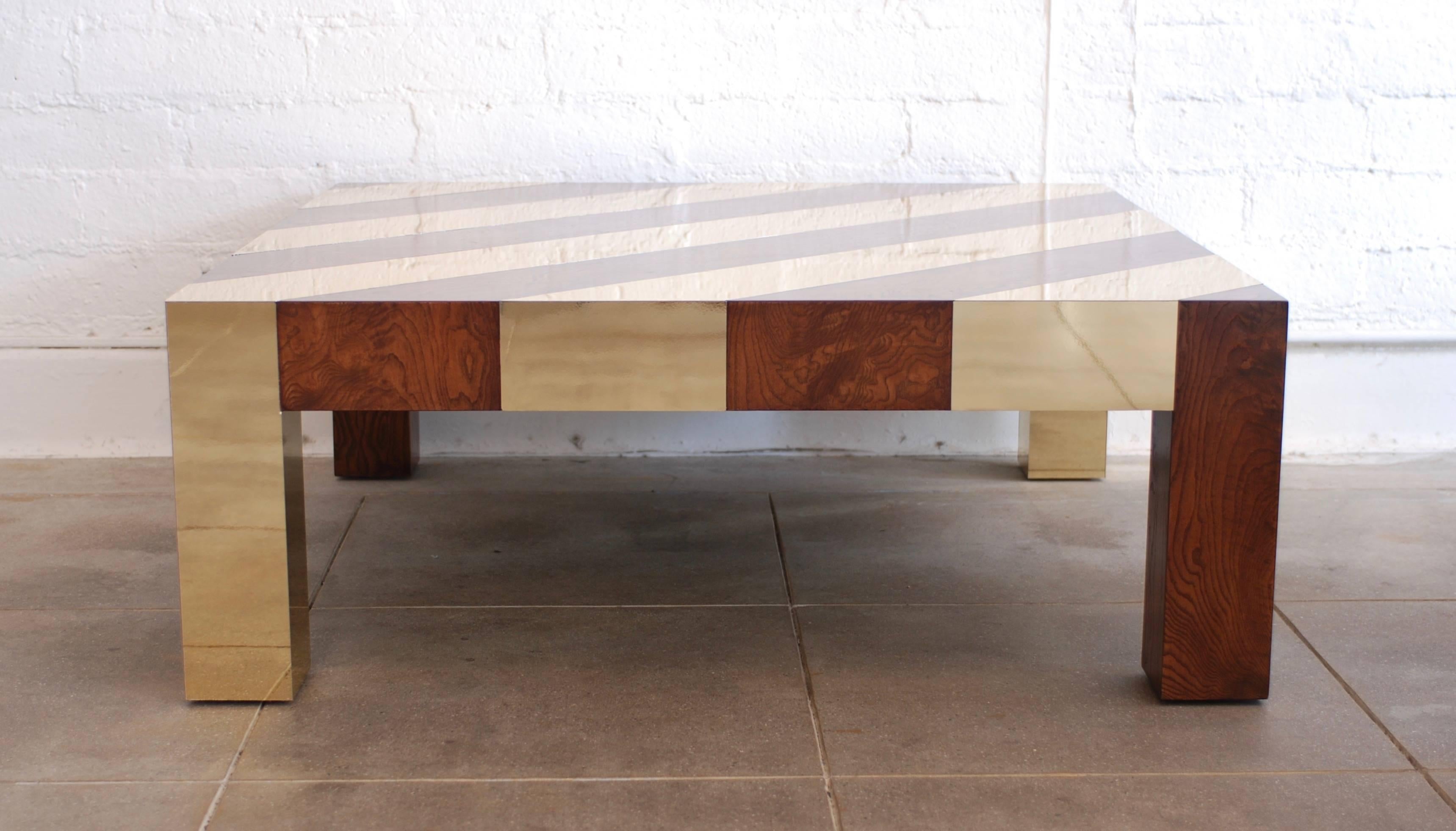 A well made sleek low 1970s style square coffee table made of brass and walnut stained wood. 
The brass inlay is set on a diagonal for maximum graphic impact.
