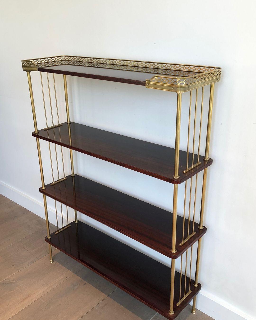 This neoclassical style shelves unit is made of mahogany and brass. This is a French work attributed to Maison Jansen. Circa 1940.
 