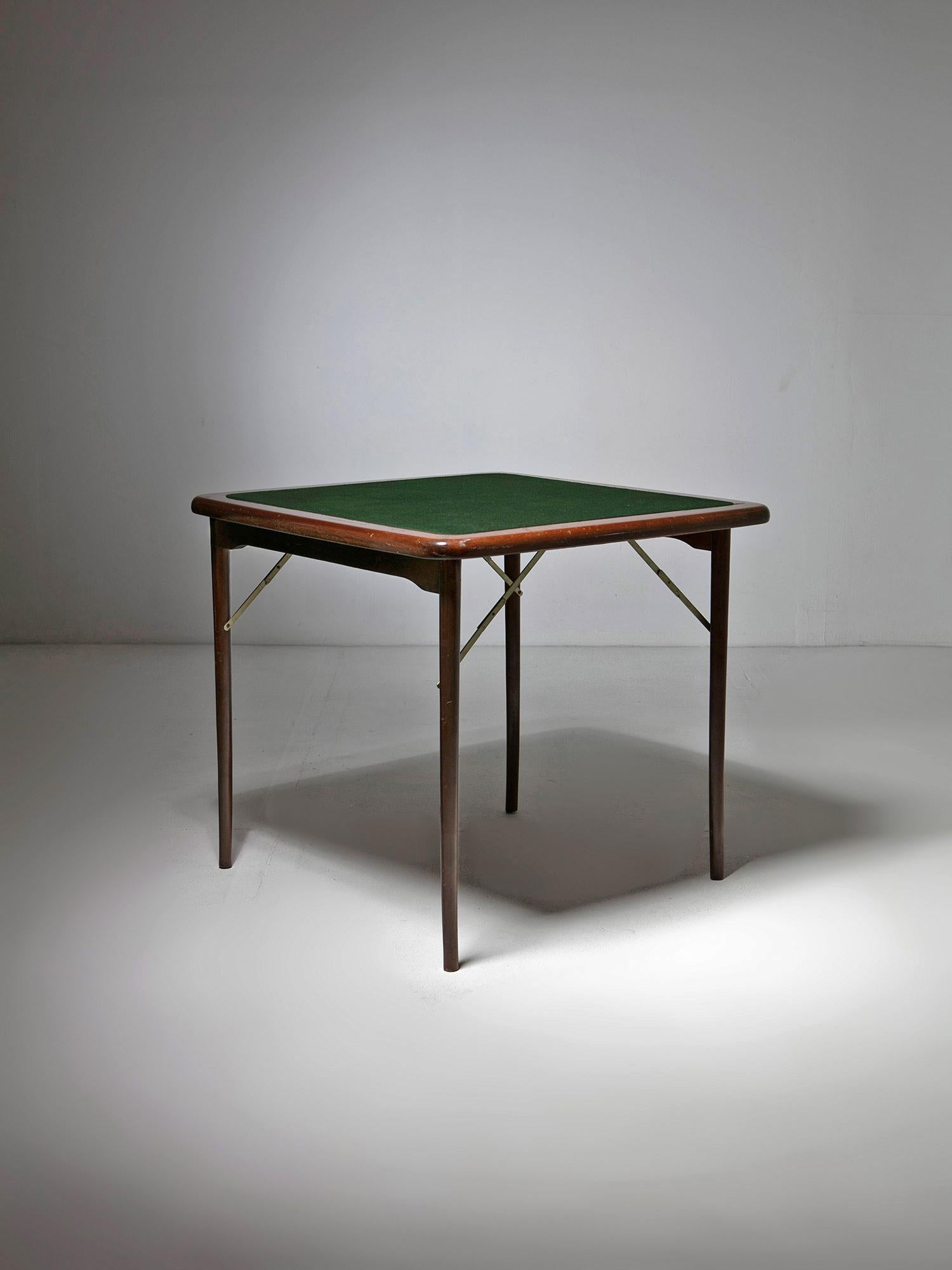 Folding table with round edges and green cloth covered top.
Brass details