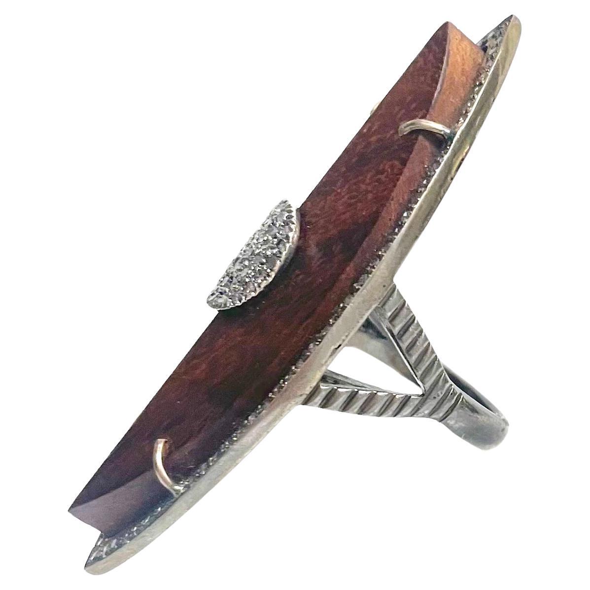 Description
You won’t go unnoticed showcasing this large one-of-a-kind statement fashion ring. 
The depth and richness of the brown hand-carved wood harmoniously joins the muted color of the diamond setting making it easy to wear anywhere! Whether
