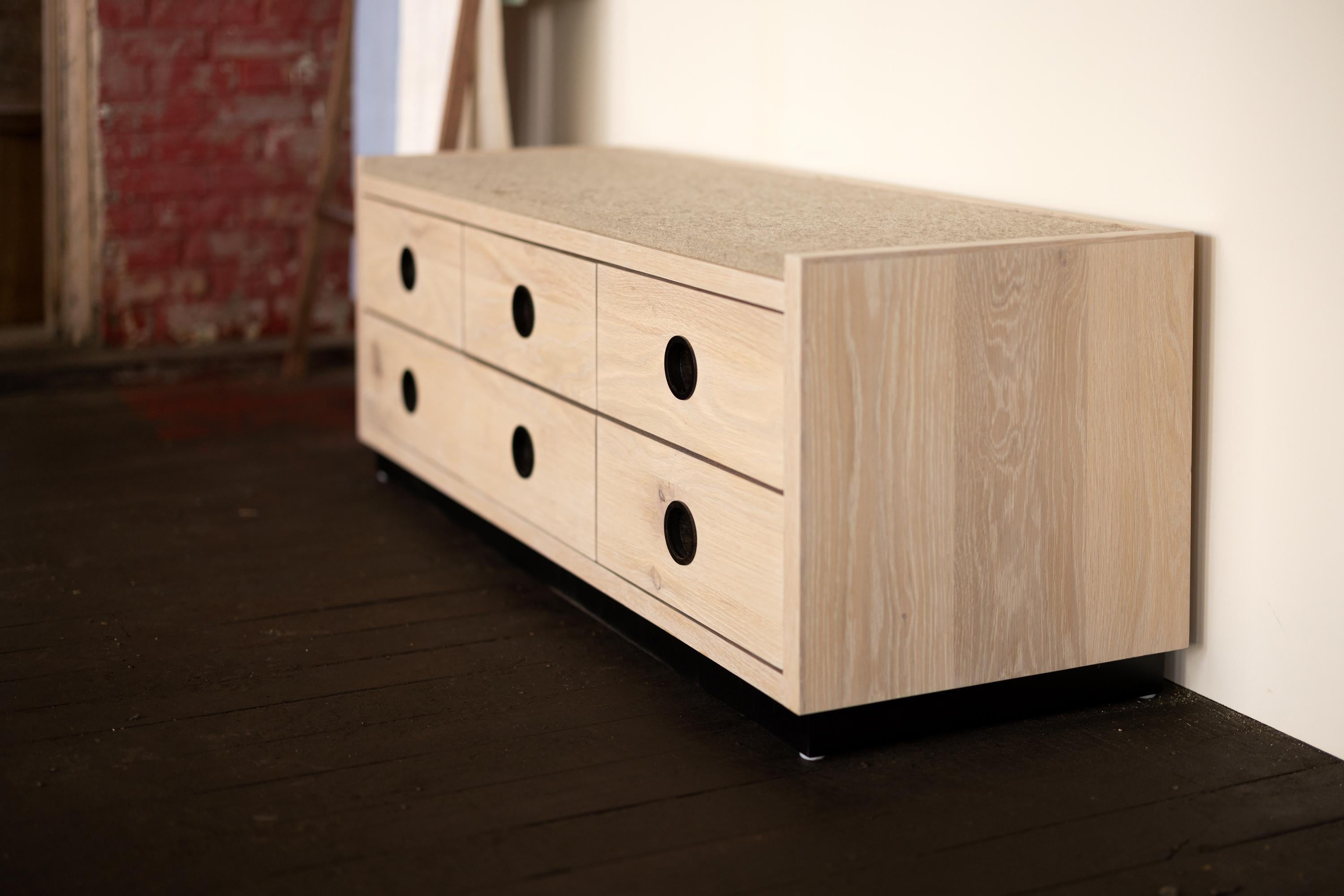 The Bank Storage Bench provides comfortable seating and discreet, organized storage. We craft the Bank Storage Bench with thick white oak and handmade, recessed, round walnut pulls. The thick felt top is low profile and comfortable.

This Wood &