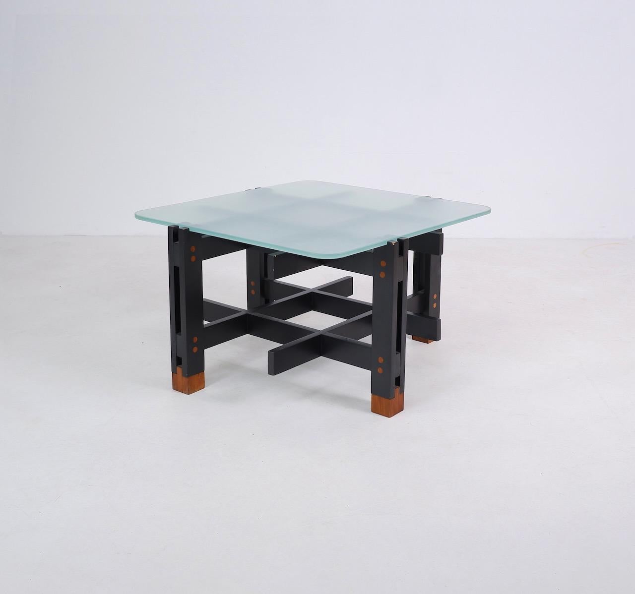Italian coffee table formed from a black painted wooden lattice frame with contrasting cherry wood detail and frosted glass top. Hints of Gio Ponti and Constructivist designs.