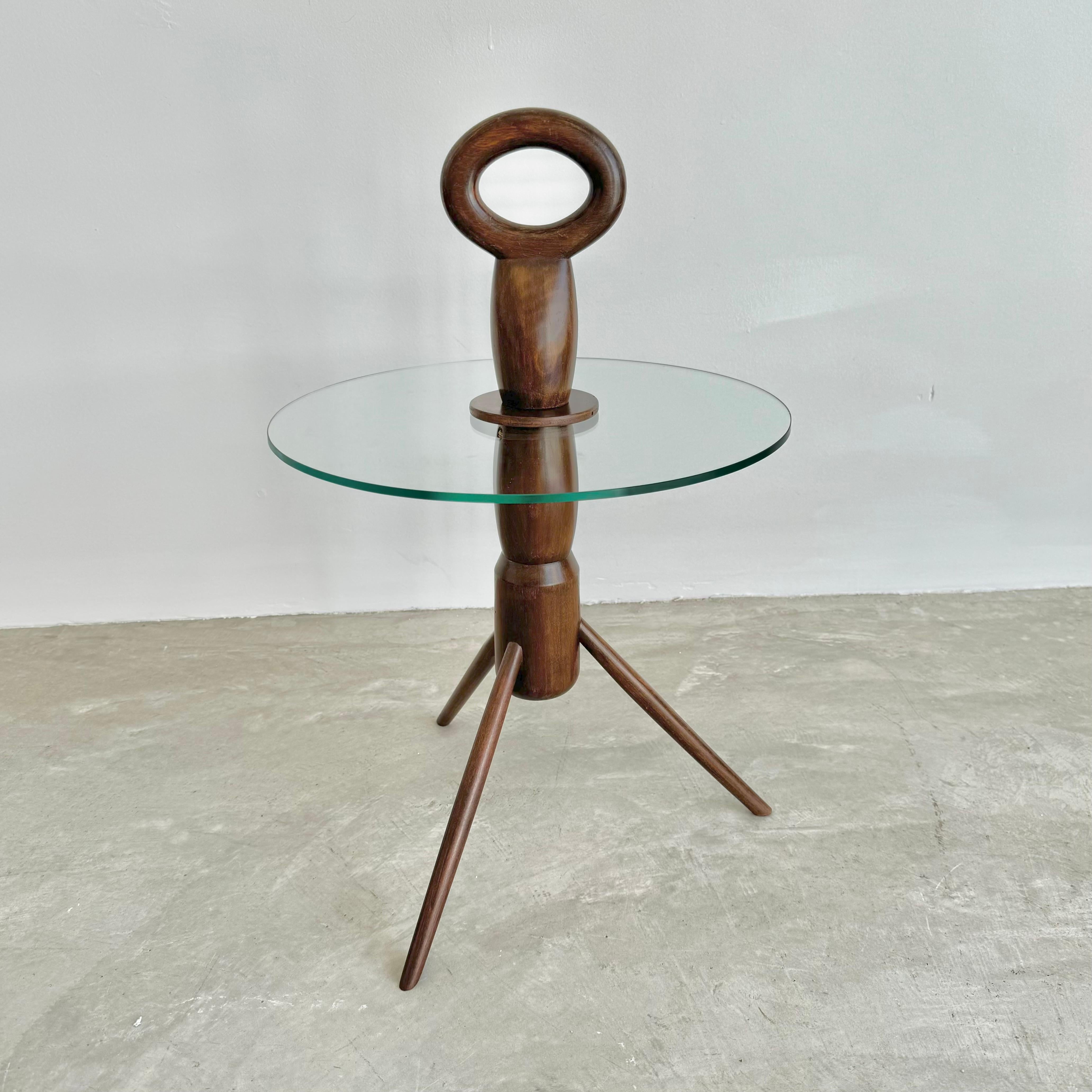 Classic wood and glass side table with tripod feet. Elegant dark wood body with a large oval handle atop. Round 1/4