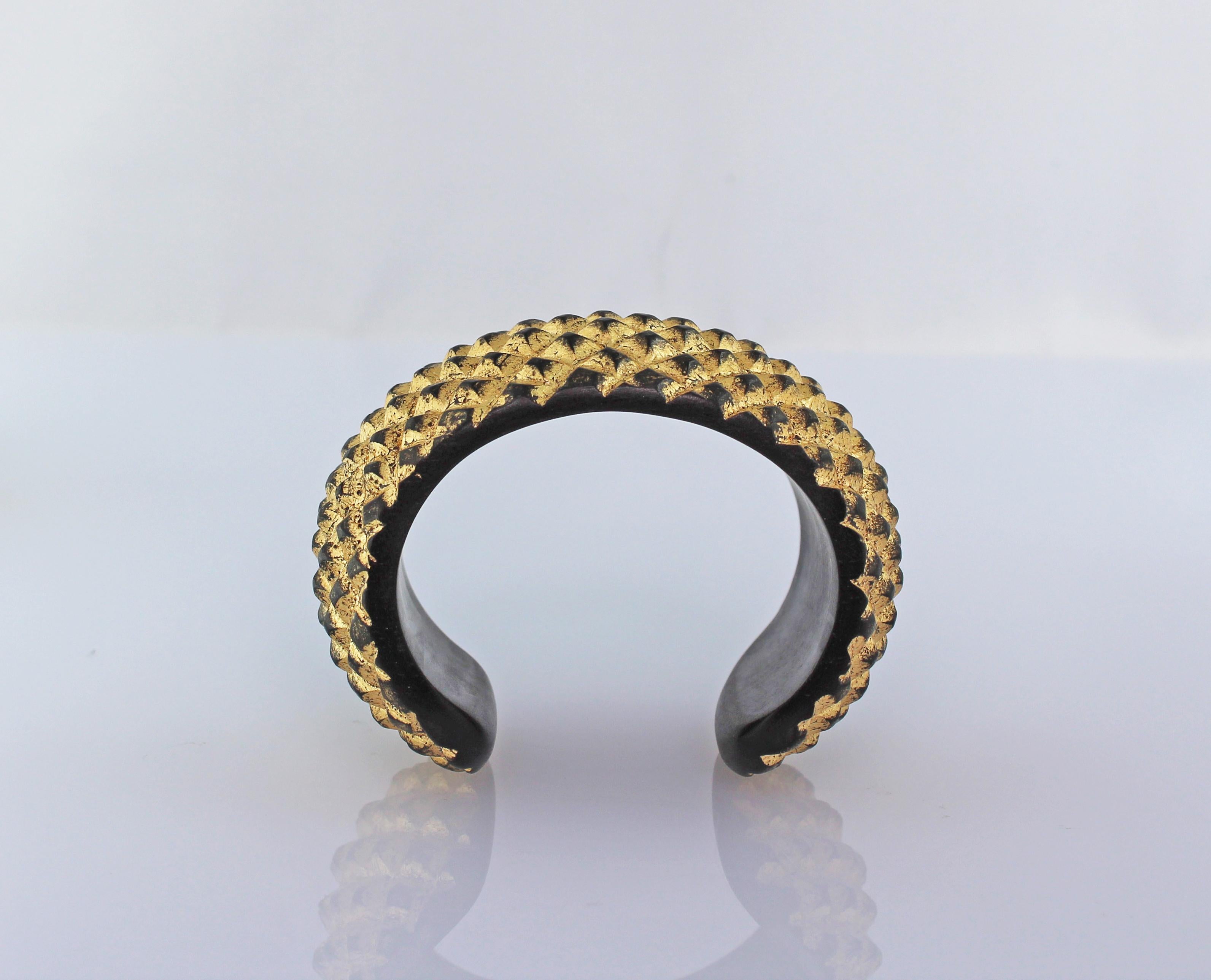 Ce modèle moderne et élégant  parure est entièrement sculptée à la main, réalisée en bois et recouverte d'une finition en feuille d'or. 
L'ensemble est composé de  un bracelet de manchette et un collier.

Tous les bijoux AVGVSTA sont neufs et n'ont