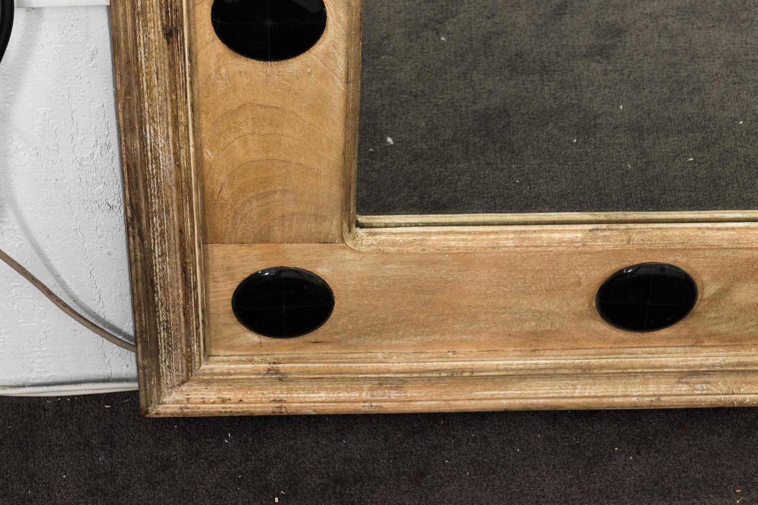 Large rectangular mirror in unfinished wooden frame embellished with ebonized horn inserts.