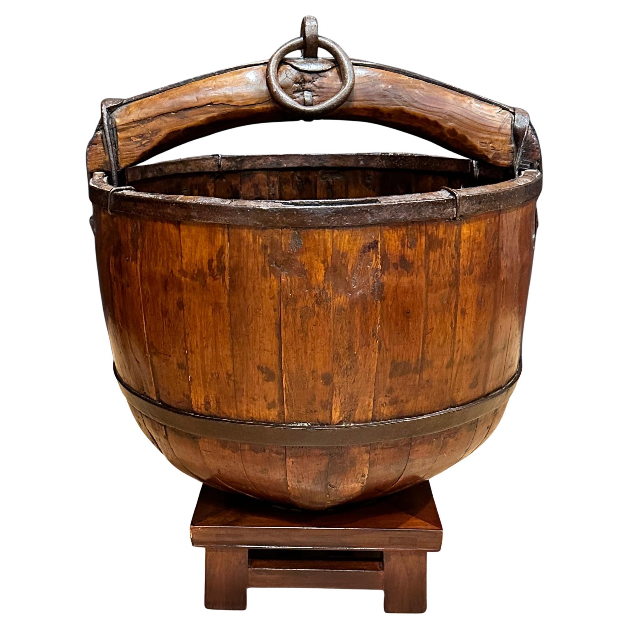 Cubo de pozo de madera y hierro sobre soporte