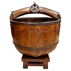 Cubo de pozo de madera y hierro sobre soporte