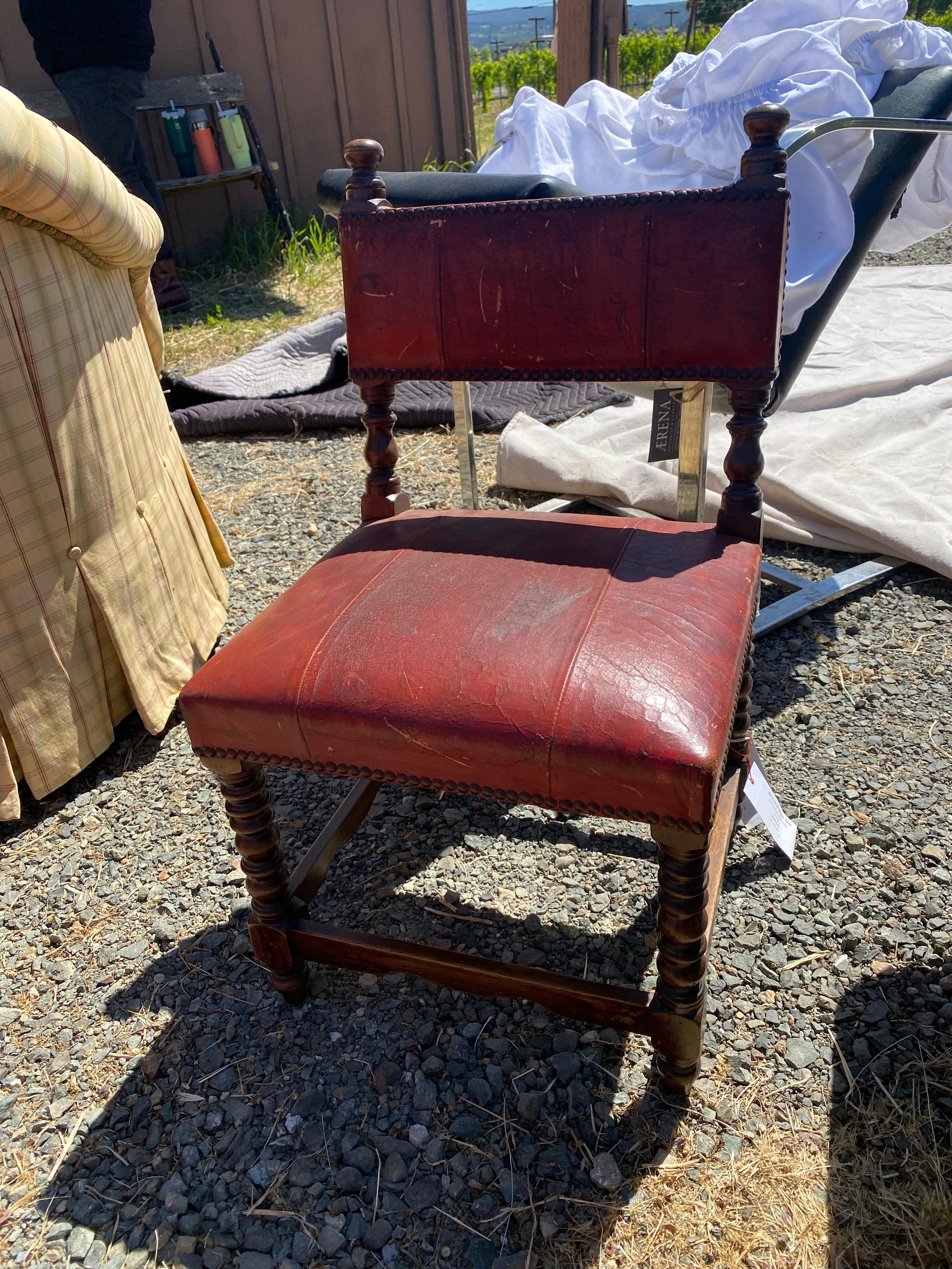 Vintage child's chair, circa 19th century. Wood frame with nailed red/brown leather seat and back.