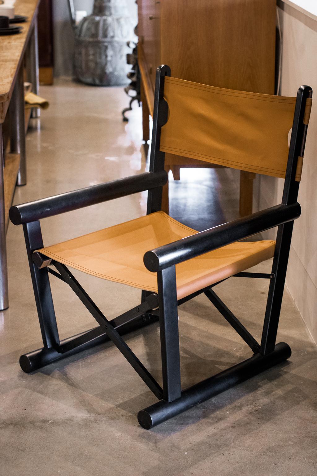 Black lacquered wood frame with new camel colored leather sling seat and back. Folds like a director's chair but very sturdy, heavy and comfortable. France, 1970's.