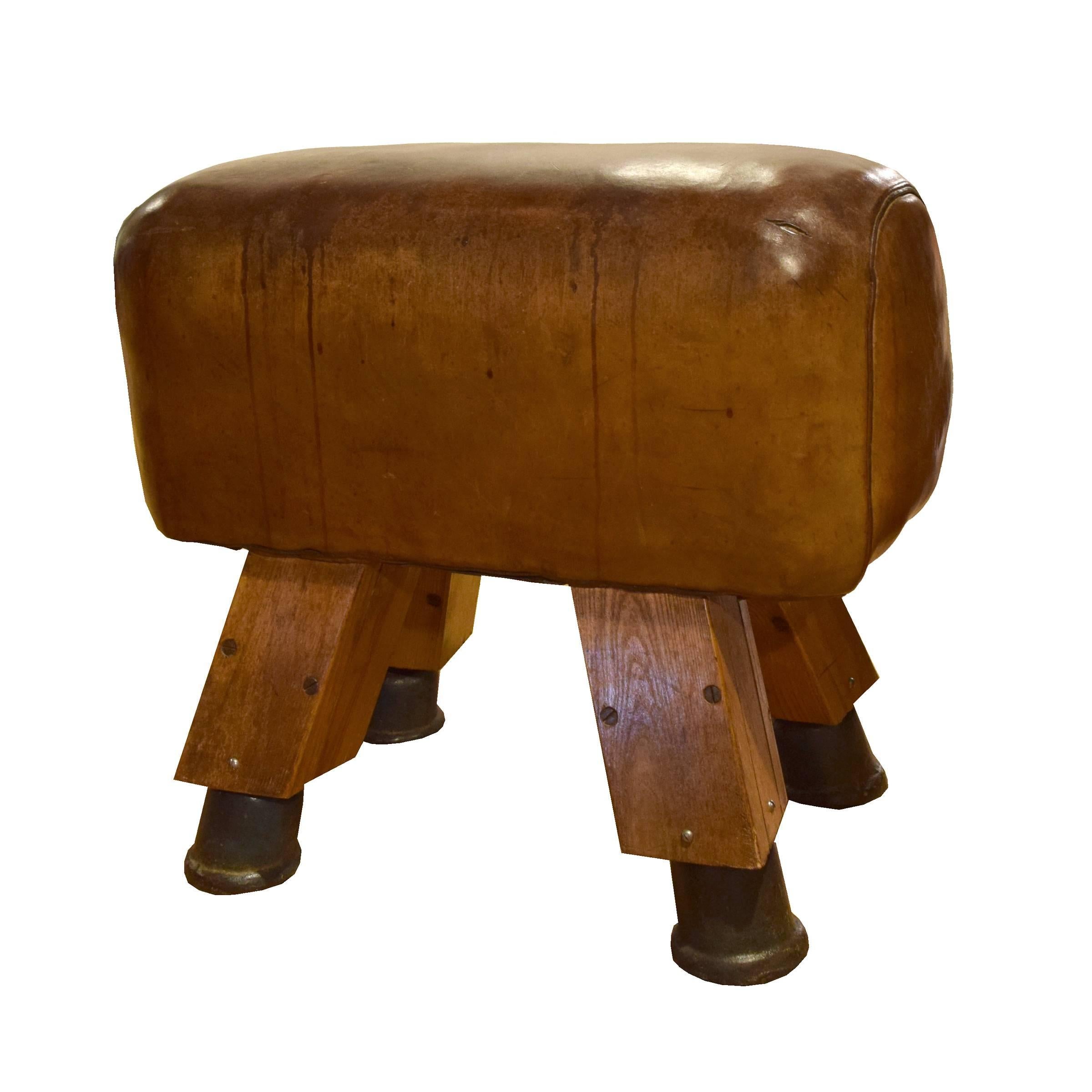 A fantastic early 20th century leather pommel horse bench with wooden legs, iron feet, and a great patina, from a gymnasium in the Czech Republic.
