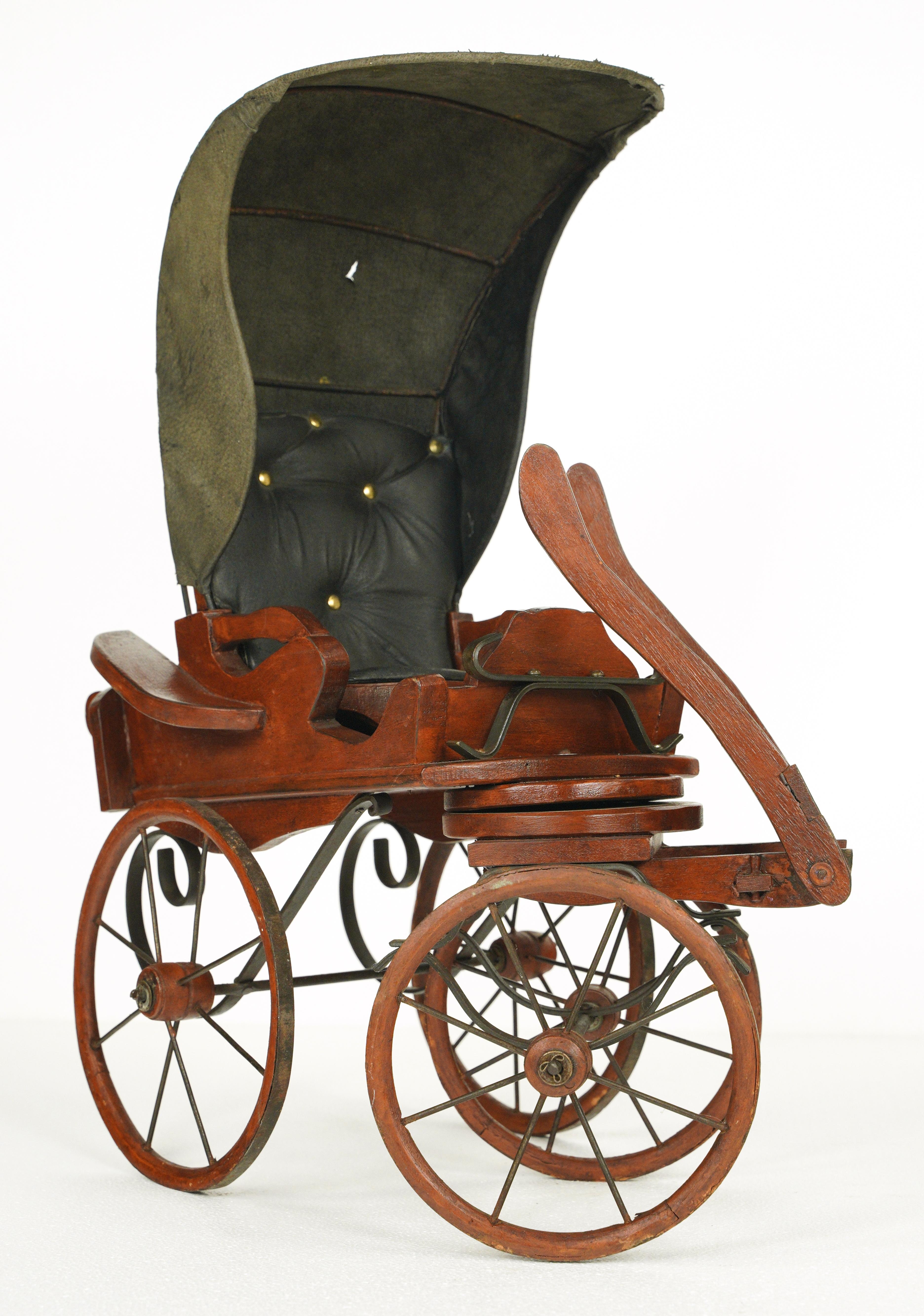 20th Century mahogany stained wood toy stagecoach carriage buggy with a black leather seat and hood. The wheels turn and pivot. Good condition with appropriate wear from age, with a minor tear in the leather and slight scratches. One available.