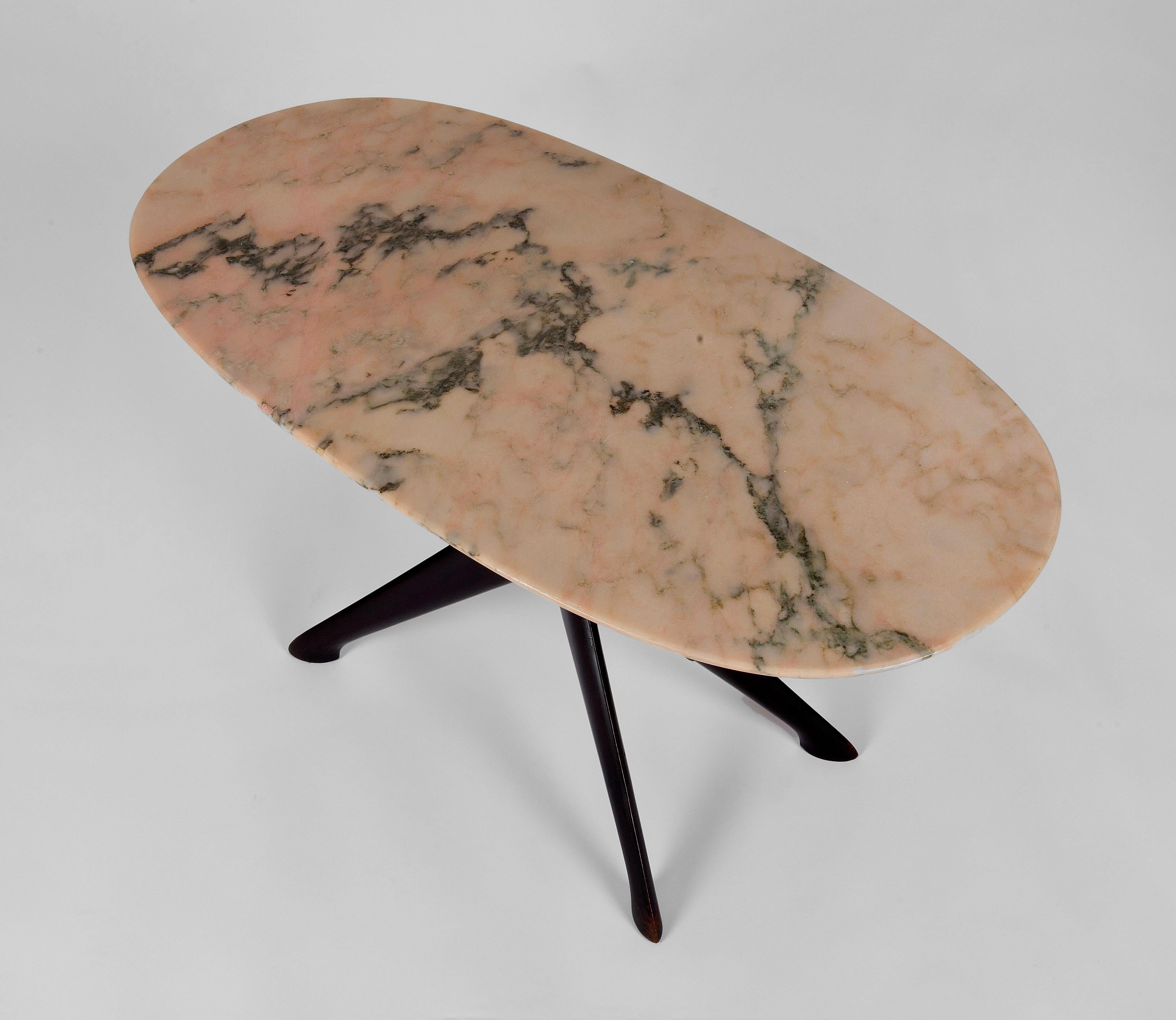 An Italian ebonised wooden coffee table from the celebrated architect and designer, Ico Parisi. This stunning example, with a pink and green oval marble table top, was produced for Parisi by the manufacturers Fratelli Rizzi who were based in