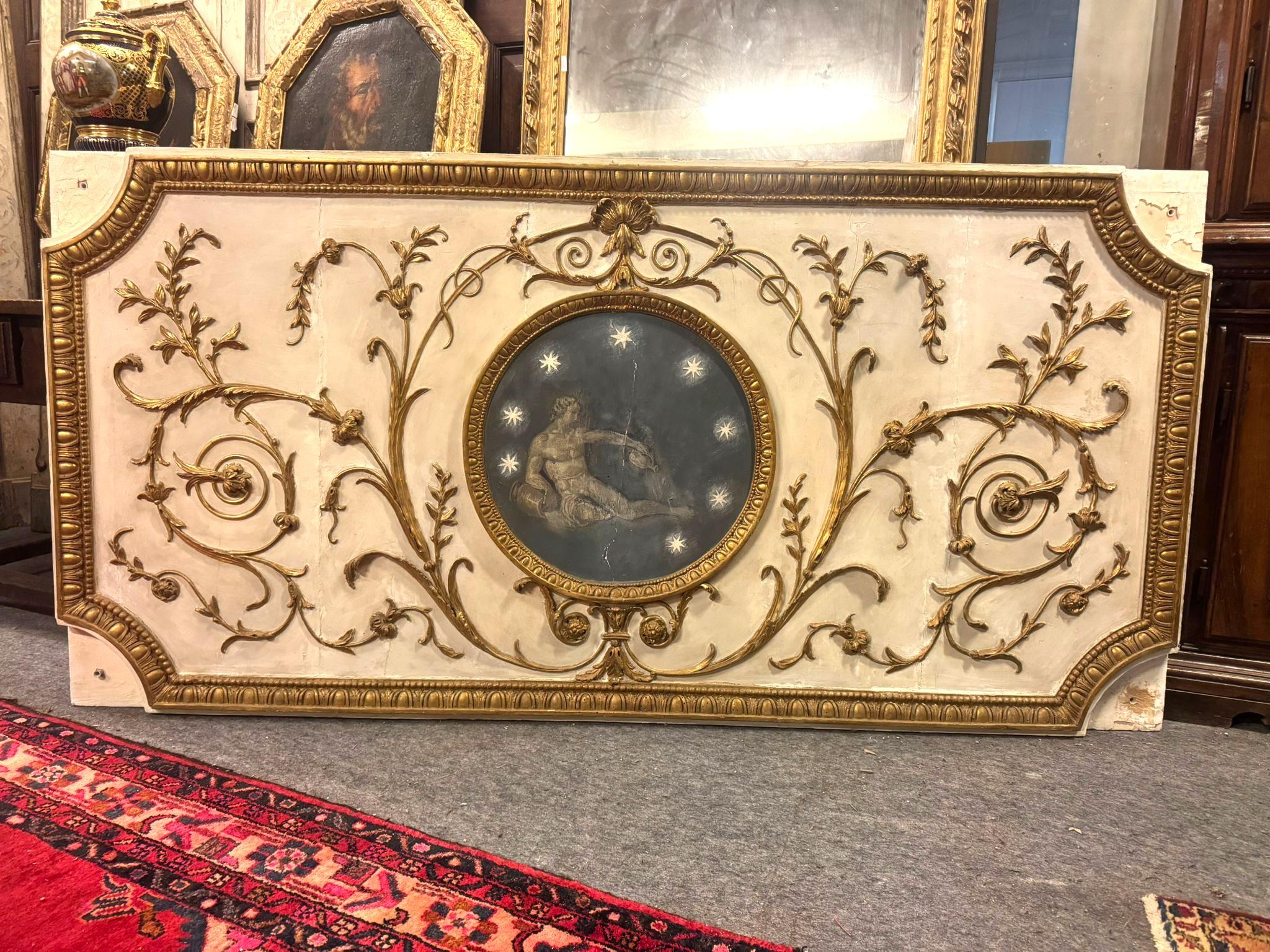 Antique wooden and plaster panel, altar frontal, lacquered with a white plaster base with carved and gilded floral and leaf decorations, Centered by a painting with a mythological figure and stars.
Original from the 18th century, from Italy. For its