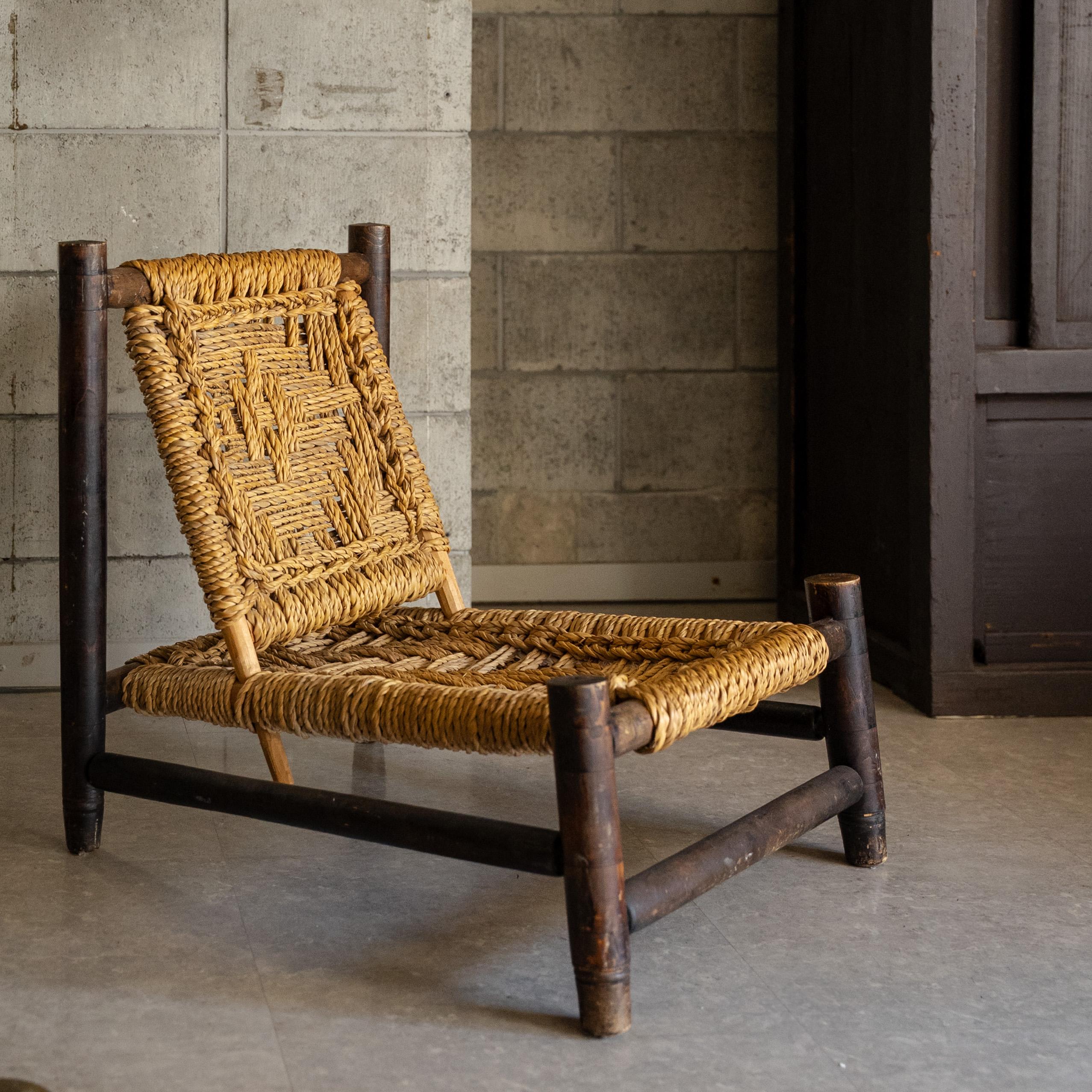 Una rara e suggestiva poltroncina disegnata da Adrien Audoux e Frida Minet. Caratterizzata da una semplicità scultorea e da un fascino artigianale, questa sedia esemplifica l'etica dei designer di utilizzare materiali onesti e naturali per creare